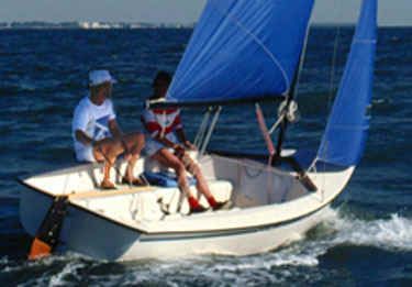 Two people are sailing a small boat in the ocean.