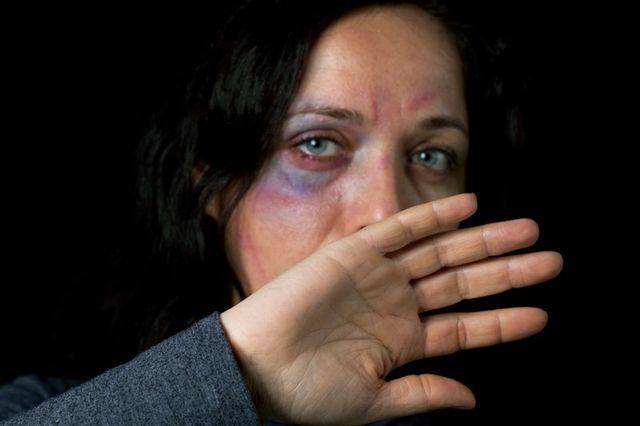 Woman covering her face after a Domestic Violence