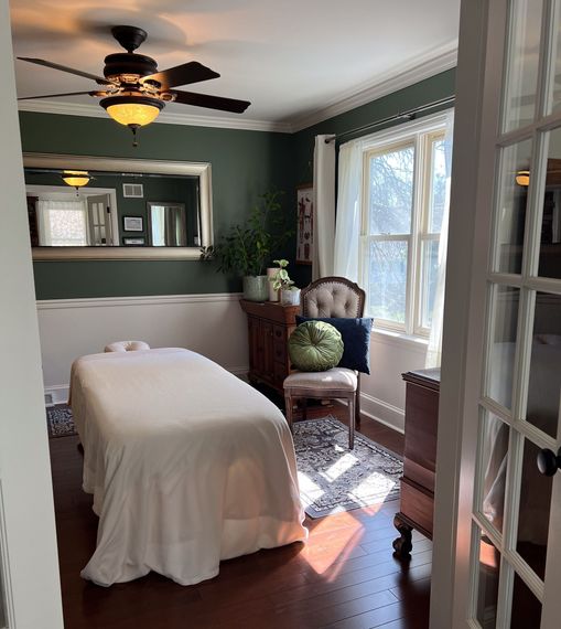 A room with a massage table and a ceiling fan