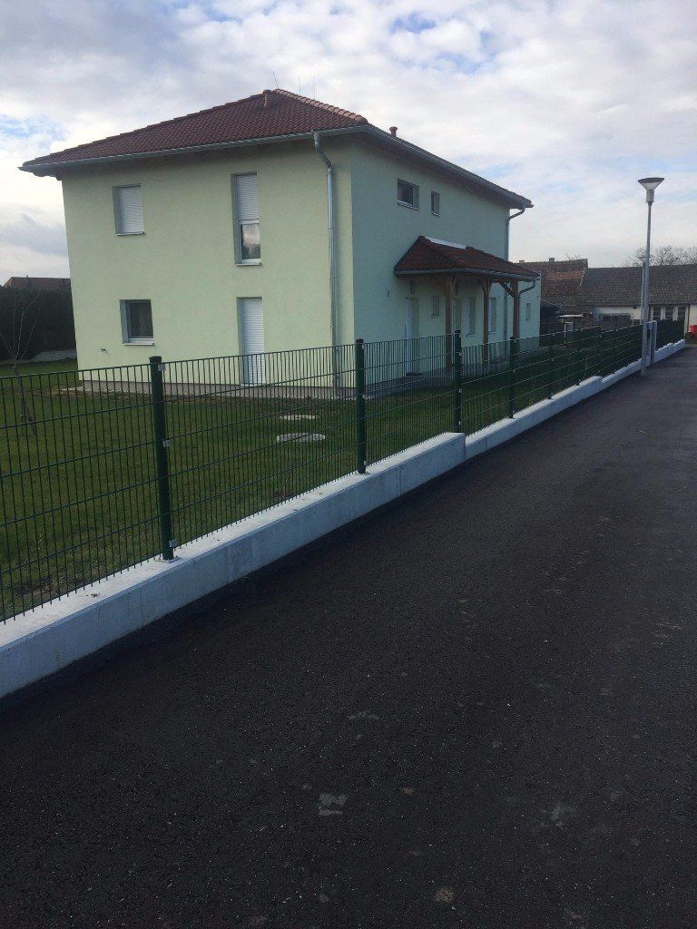 Ein Haus mit einem Zaun davor