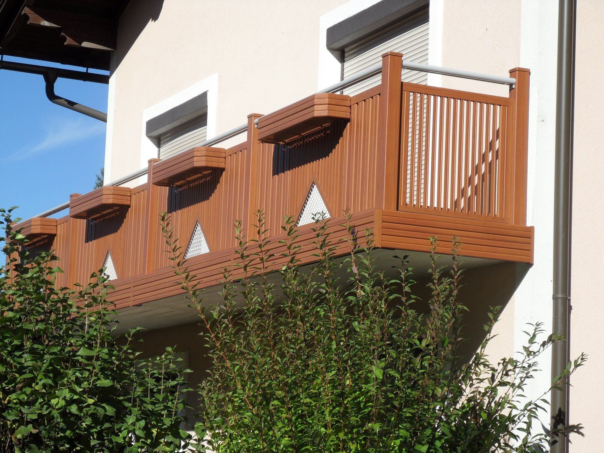 Ein Balkon mit einem Holzgeländer an der Seite eines Hauses