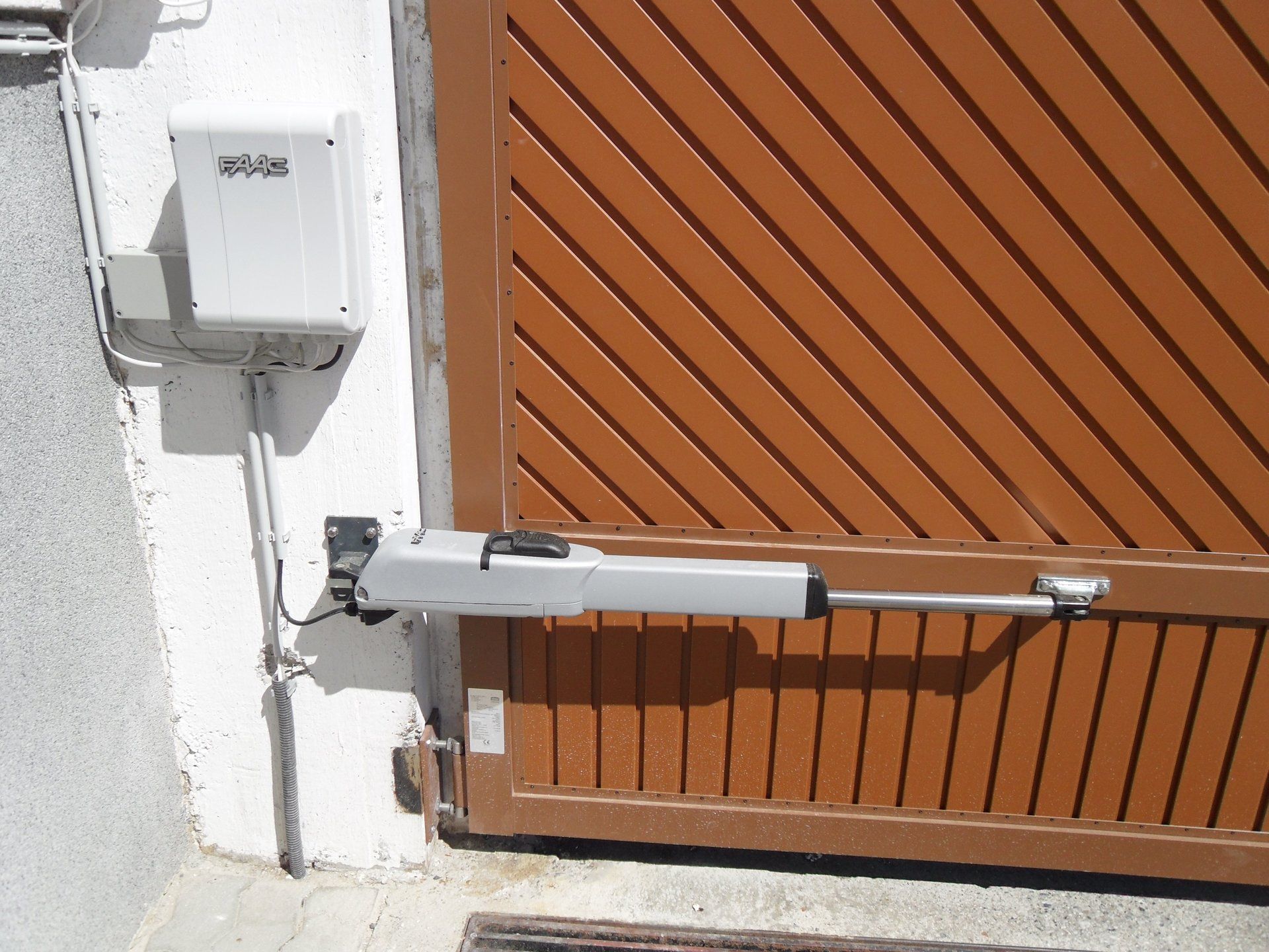 Ein Tor mit einem daran befestigten Motor und einem Kästchen an der Wand mit der Aufschrift „a“