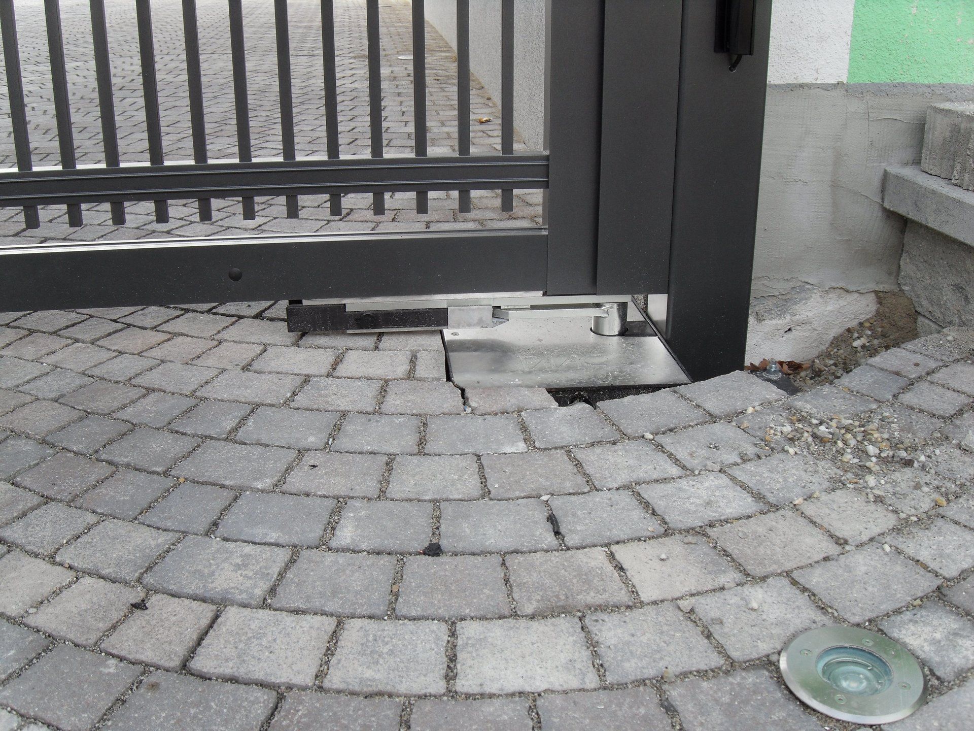 Ein gemauerter Gehweg mit einem Tor im Hintergrund