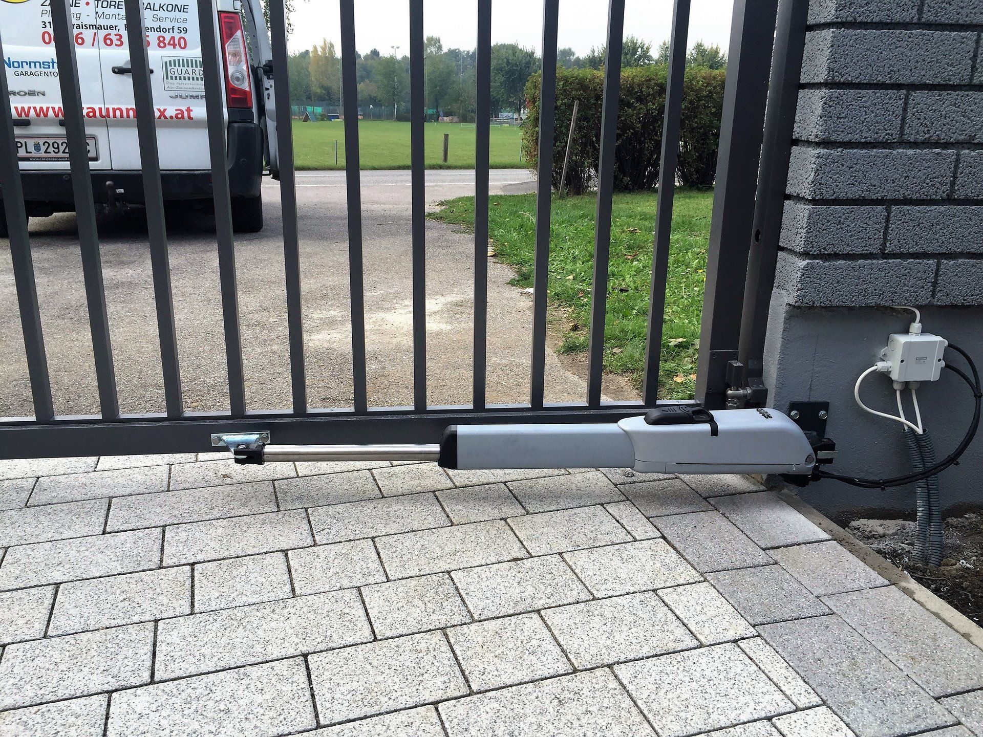 Ein weißer Lieferwagen steht hinter einem offenen Tor