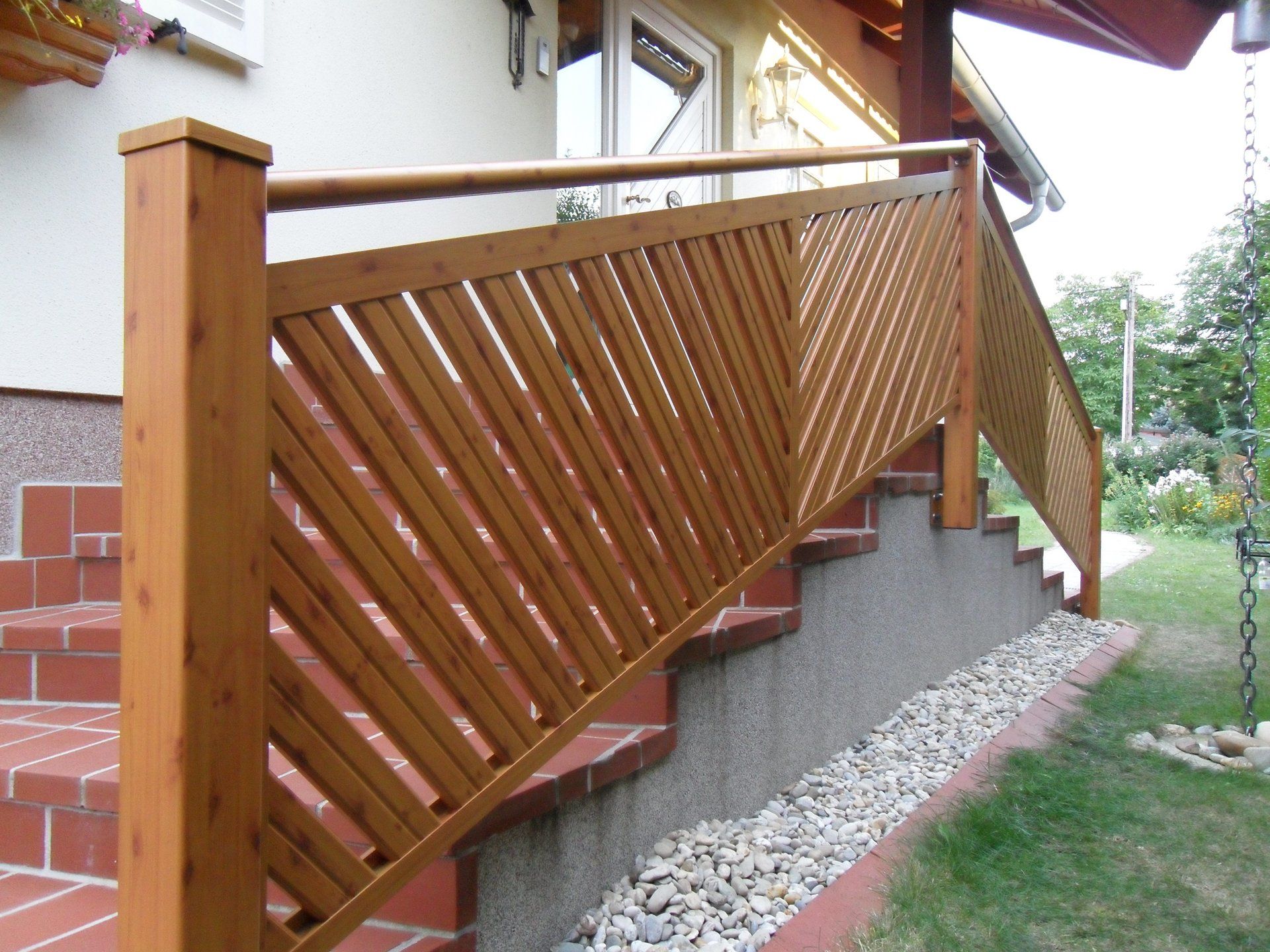 Ein Holzgeländer umgibt eine Treppe, die zu einem Haus hinaufführt
