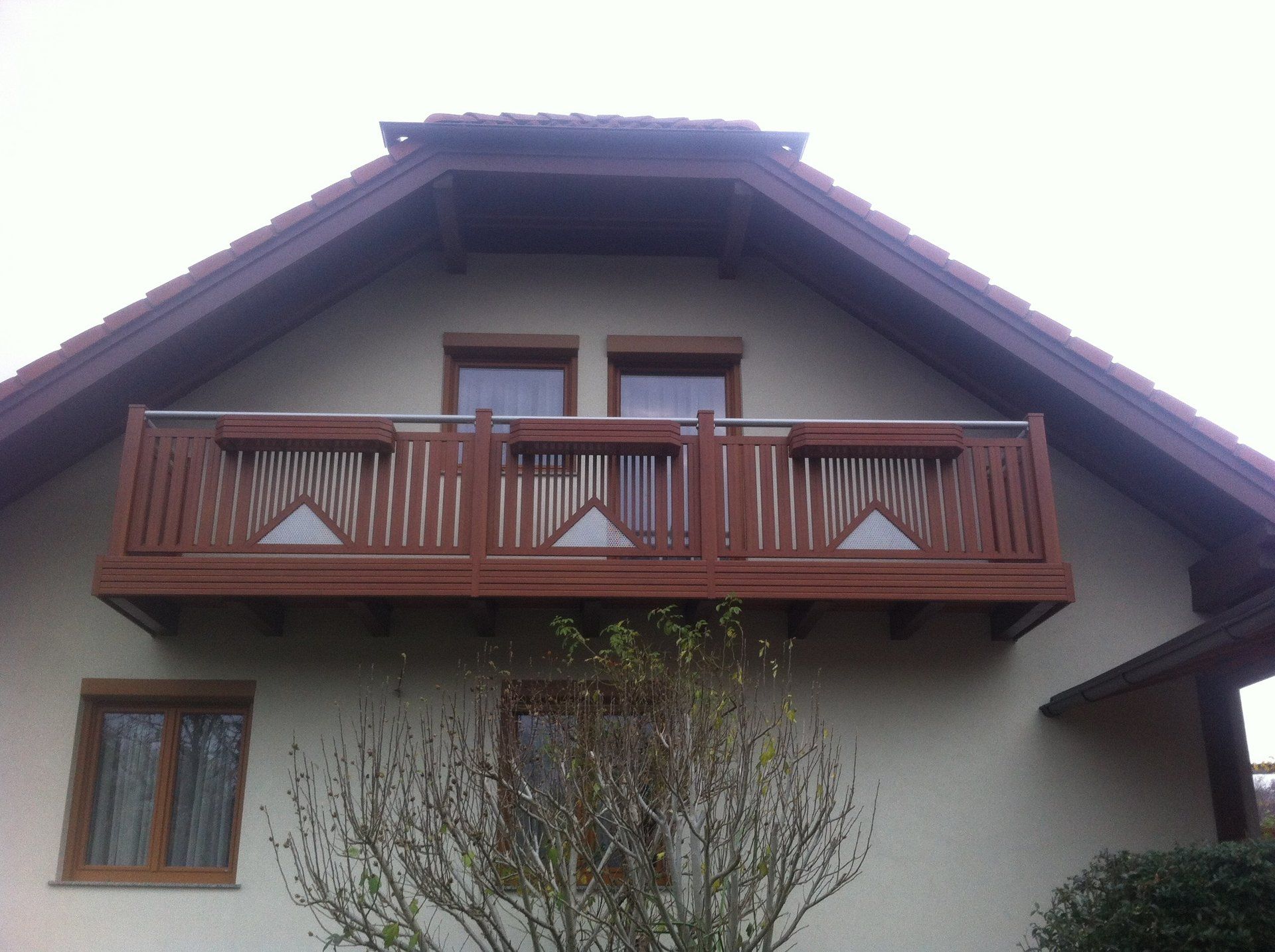 Ein Haus mit einem Balkon oben drauf.