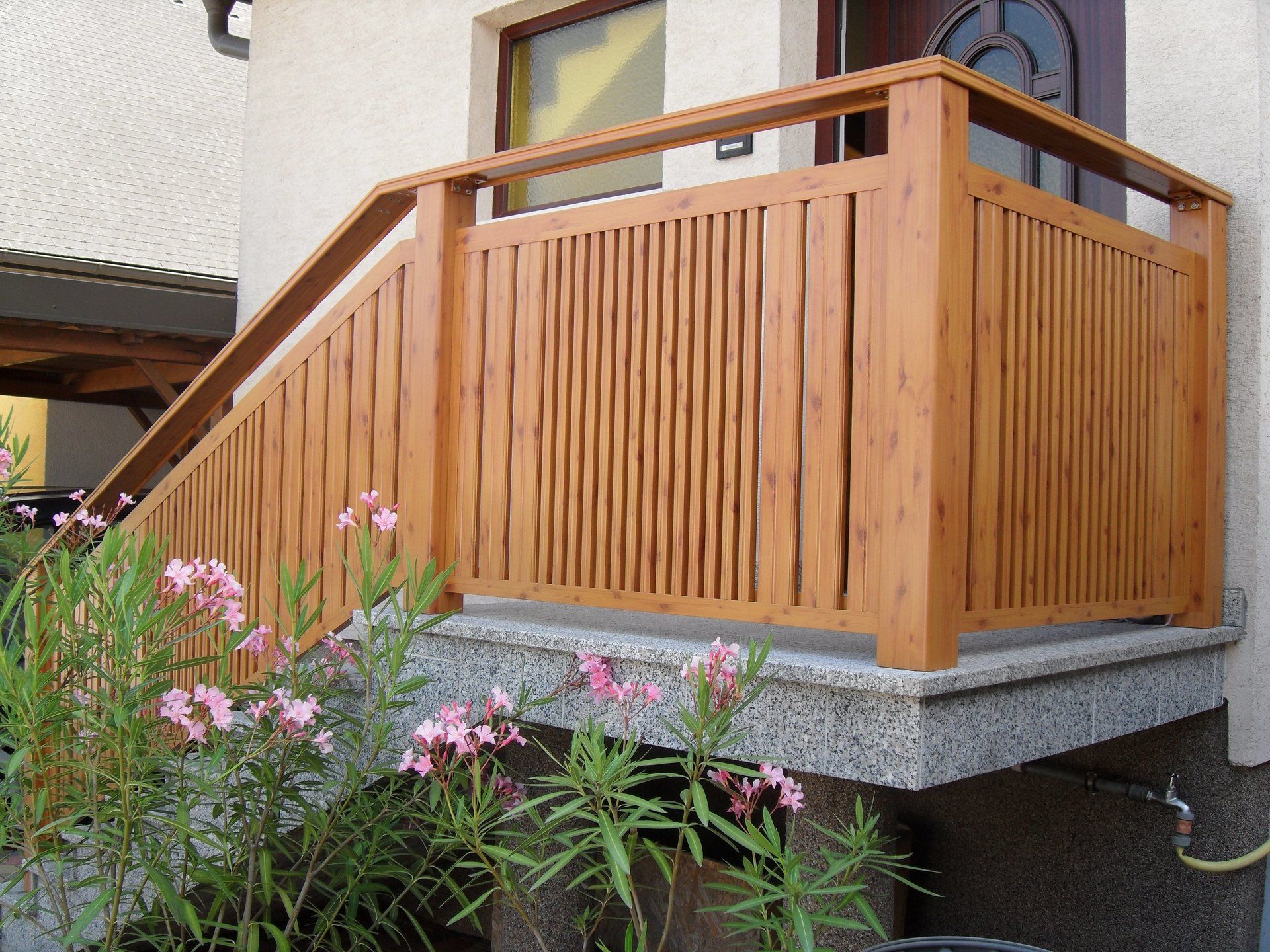 Ein Holzbalkon mit Blumen davor