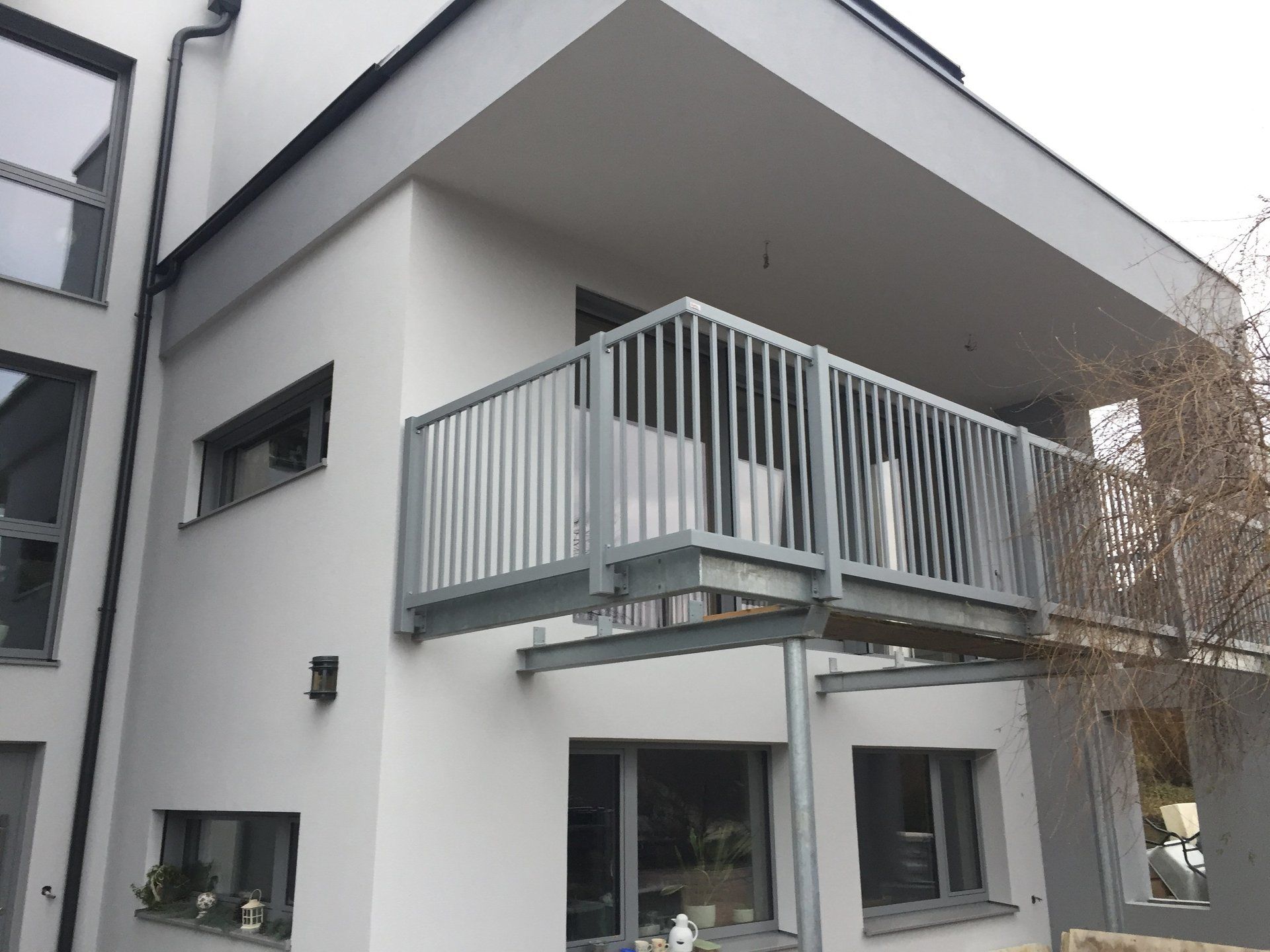 Ein weißes Gebäude mit einem Balkon an der Seite.