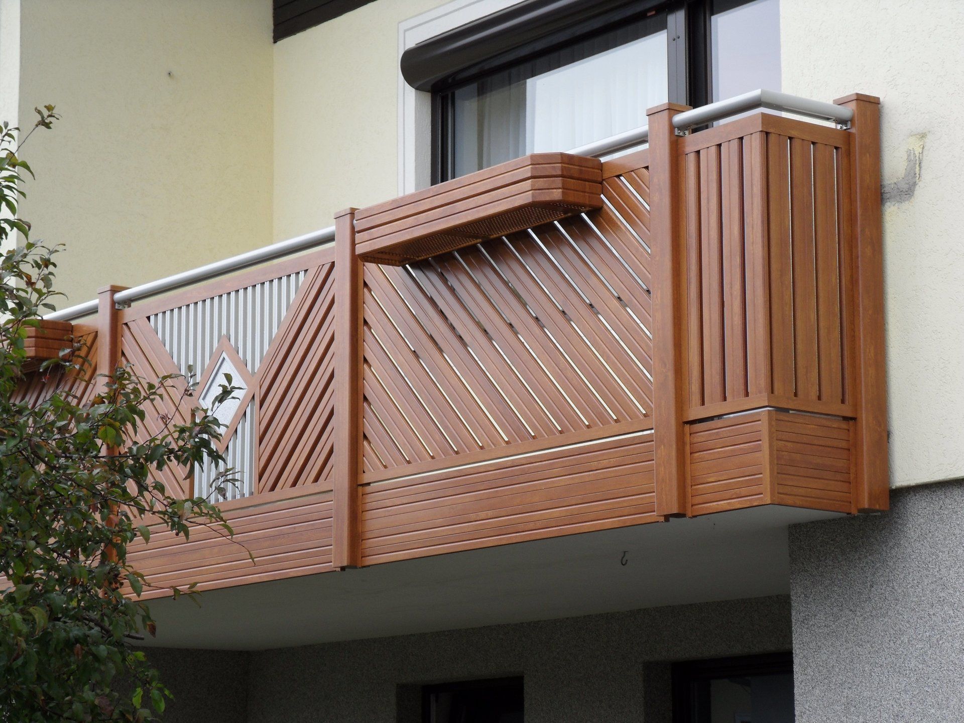 Ein Balkon mit einem Holzgeländer an der Seite eines Gebäudes