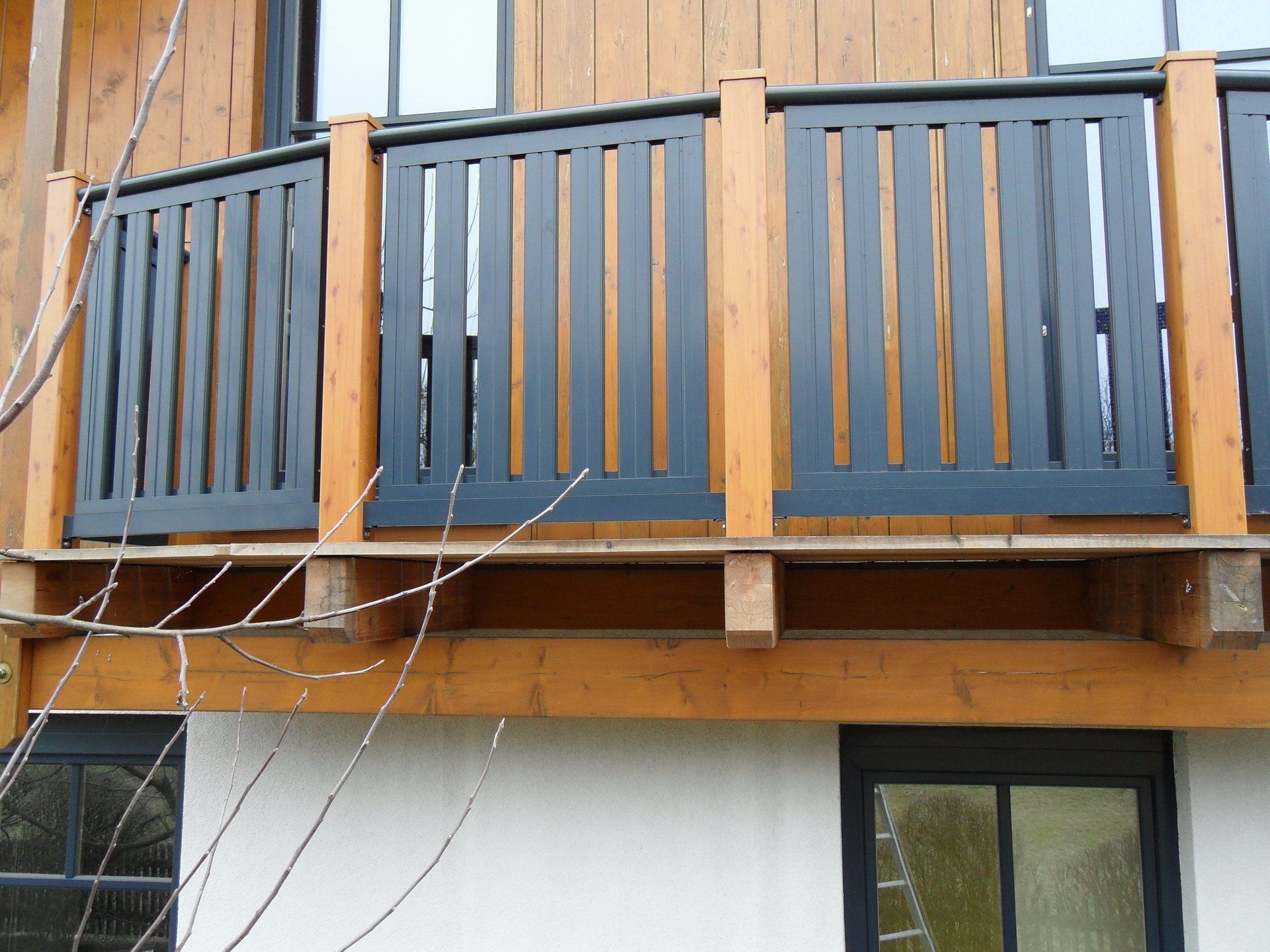 Ein Balkon mit einem Holzgeländer an der Seite eines Hauses