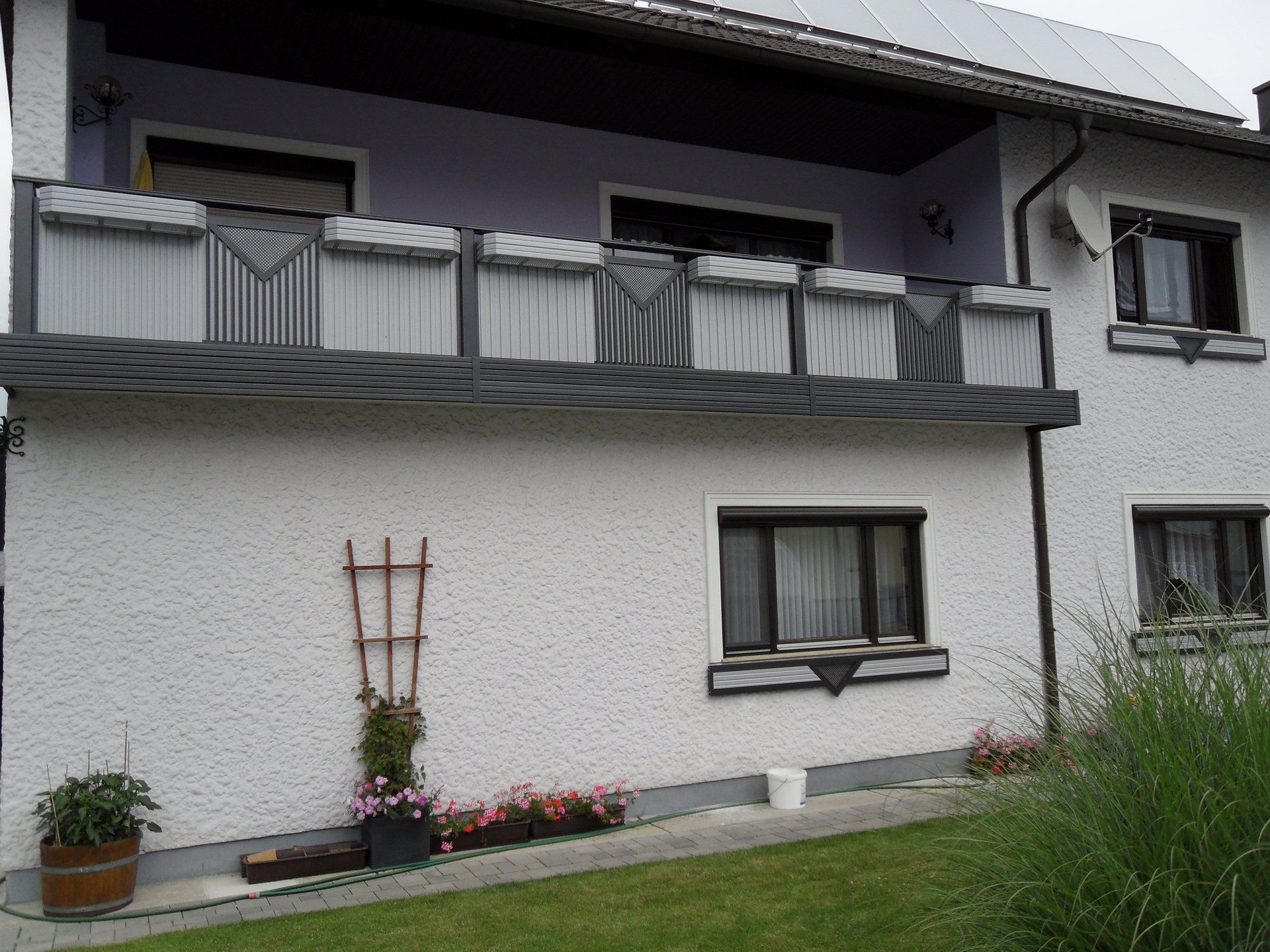 Ein weißes Haus mit einem Balkon im zweiten Stock