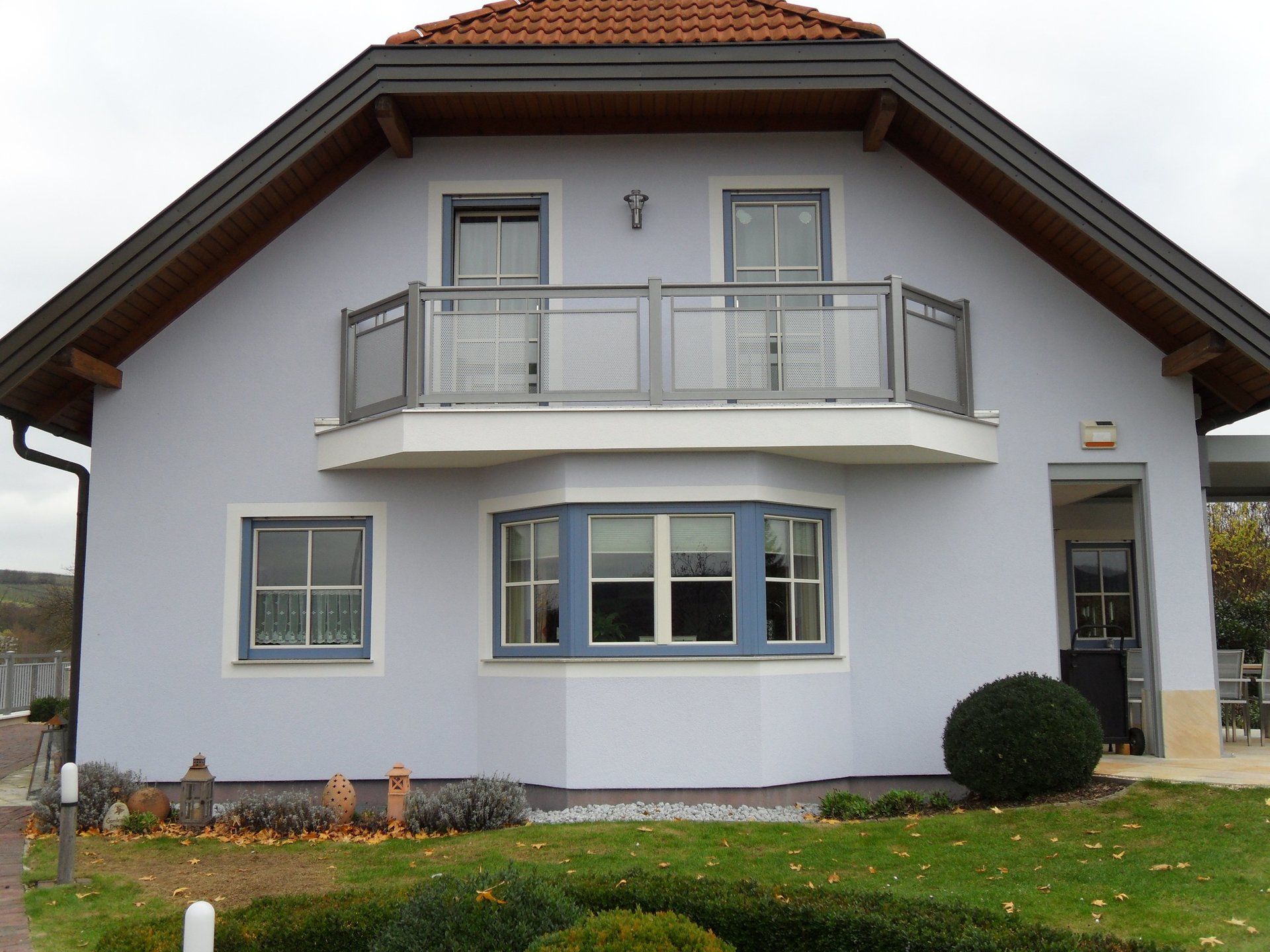 Ein weißes Haus mit einem Balkon und vielen Fenstern
