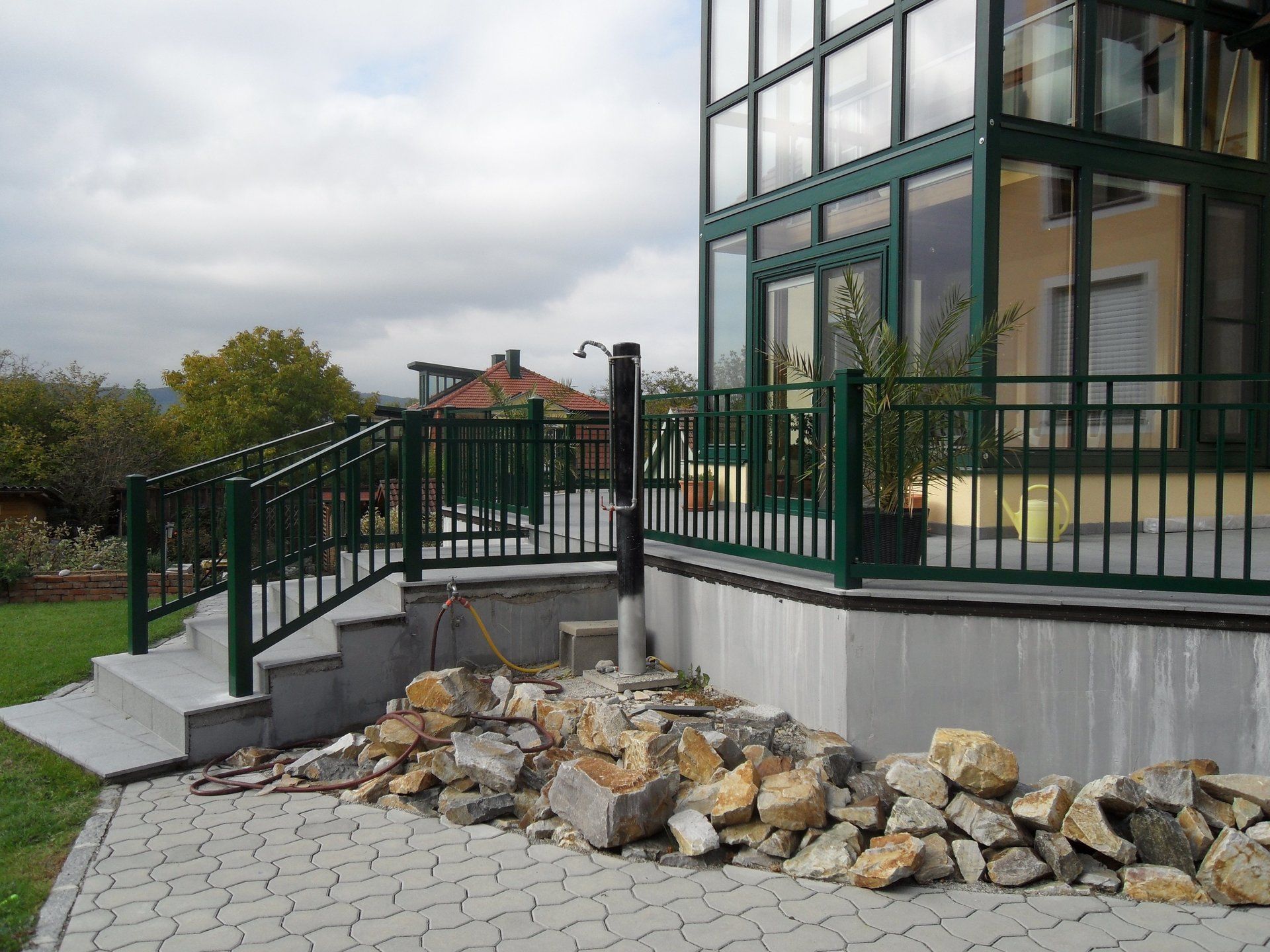 Ein Haus mit einem grünen Geländer und einer Treppe, die dorthin führt