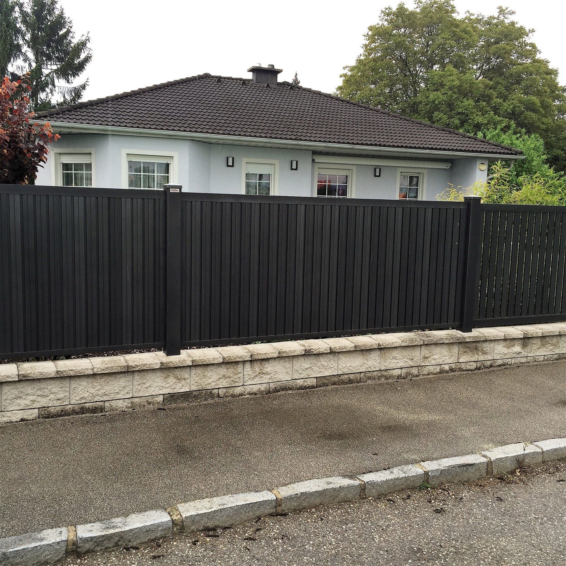 Ein Haus mit einem schwarzen Zaun davor