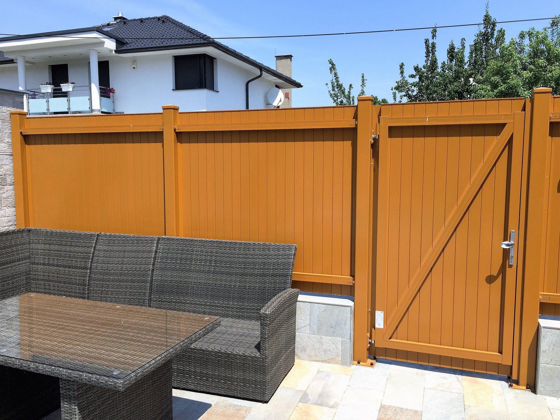 Ein Holzzaun mit einem Tor und einer Couch davor