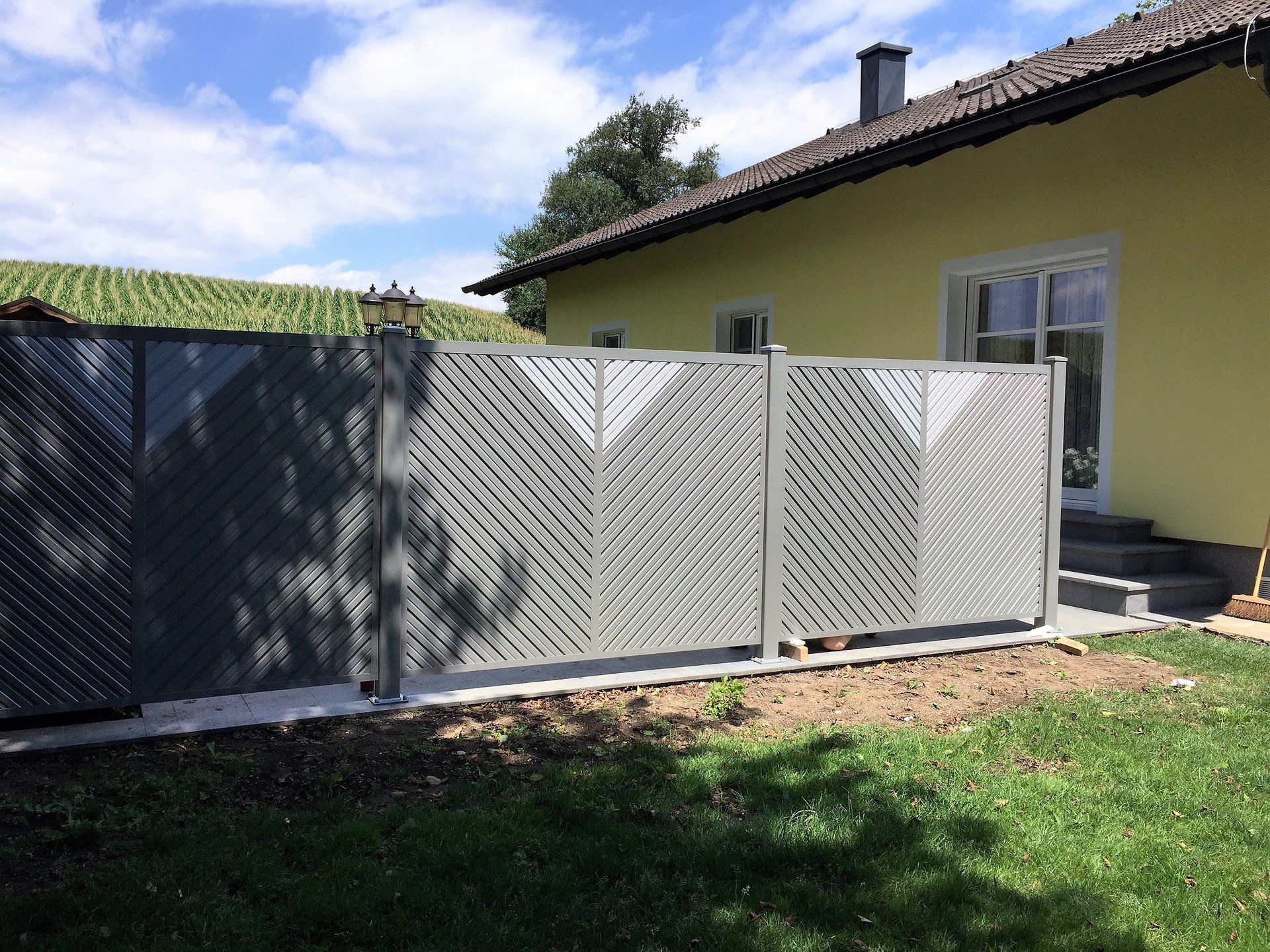 Ein gelbes Haus mit einem Zaun davor.