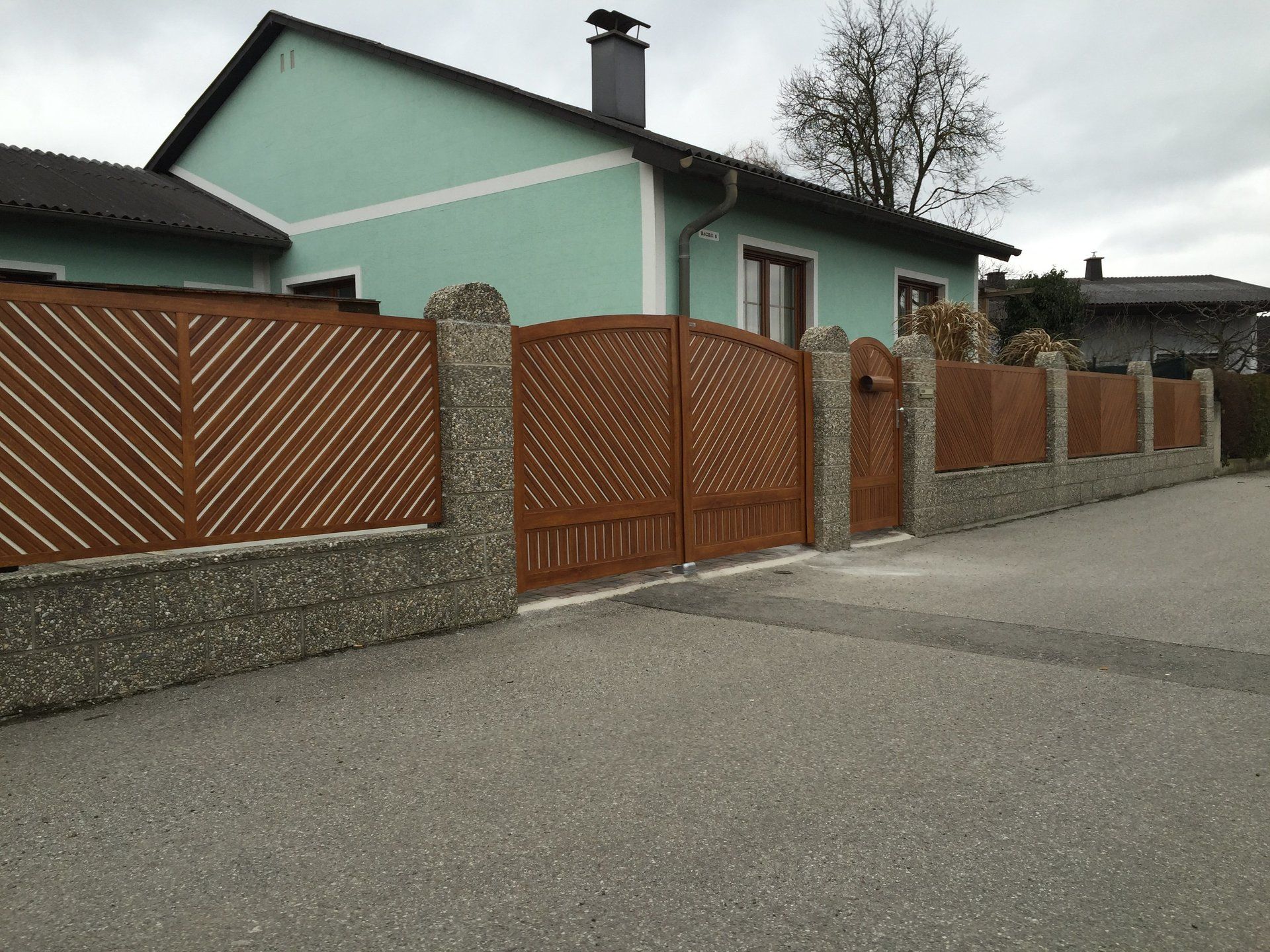 Ein Haus mit einem Zaun und einem Tor davor