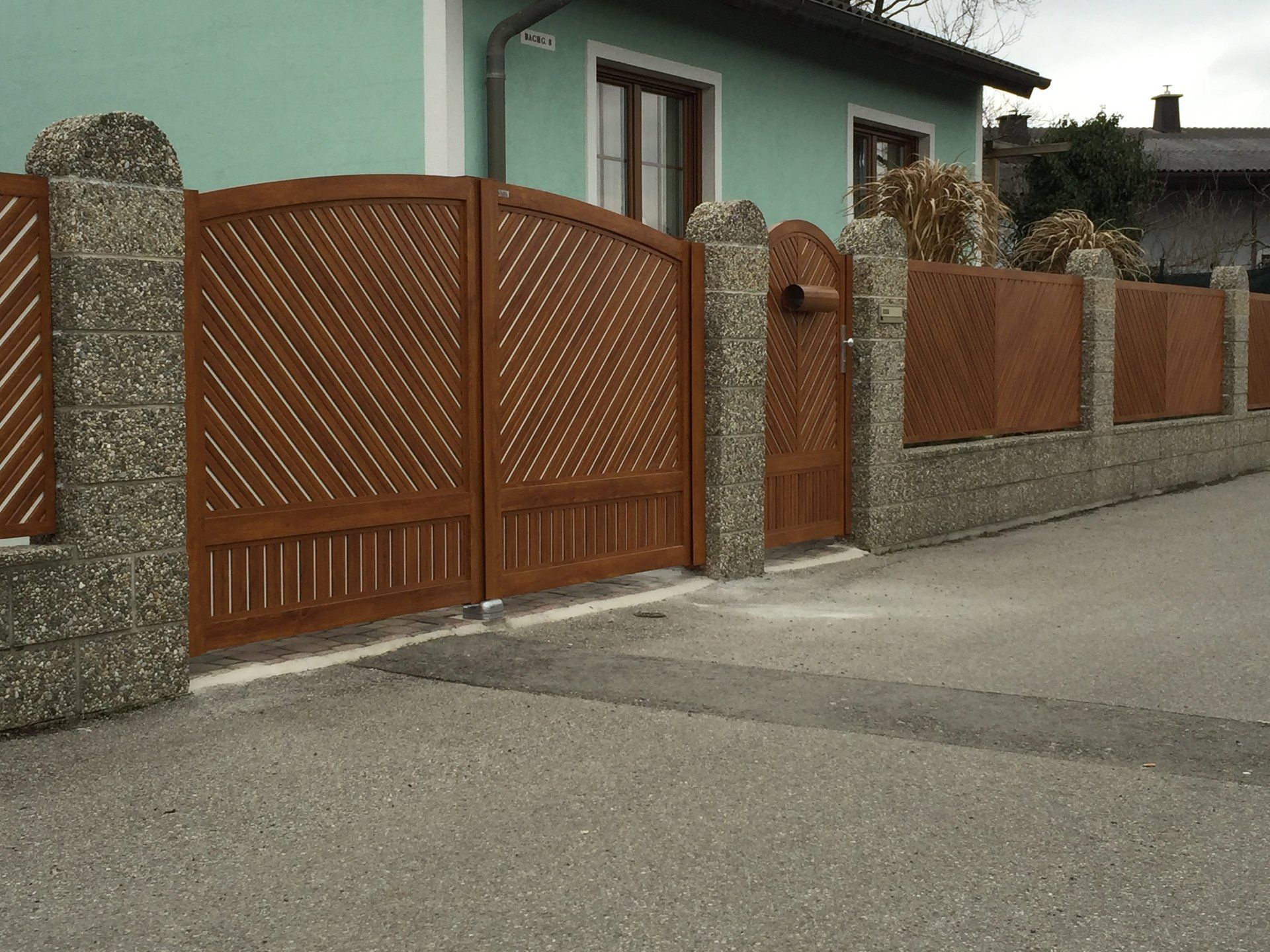 Ein Gewächshaus mit Holzzaun und Tor