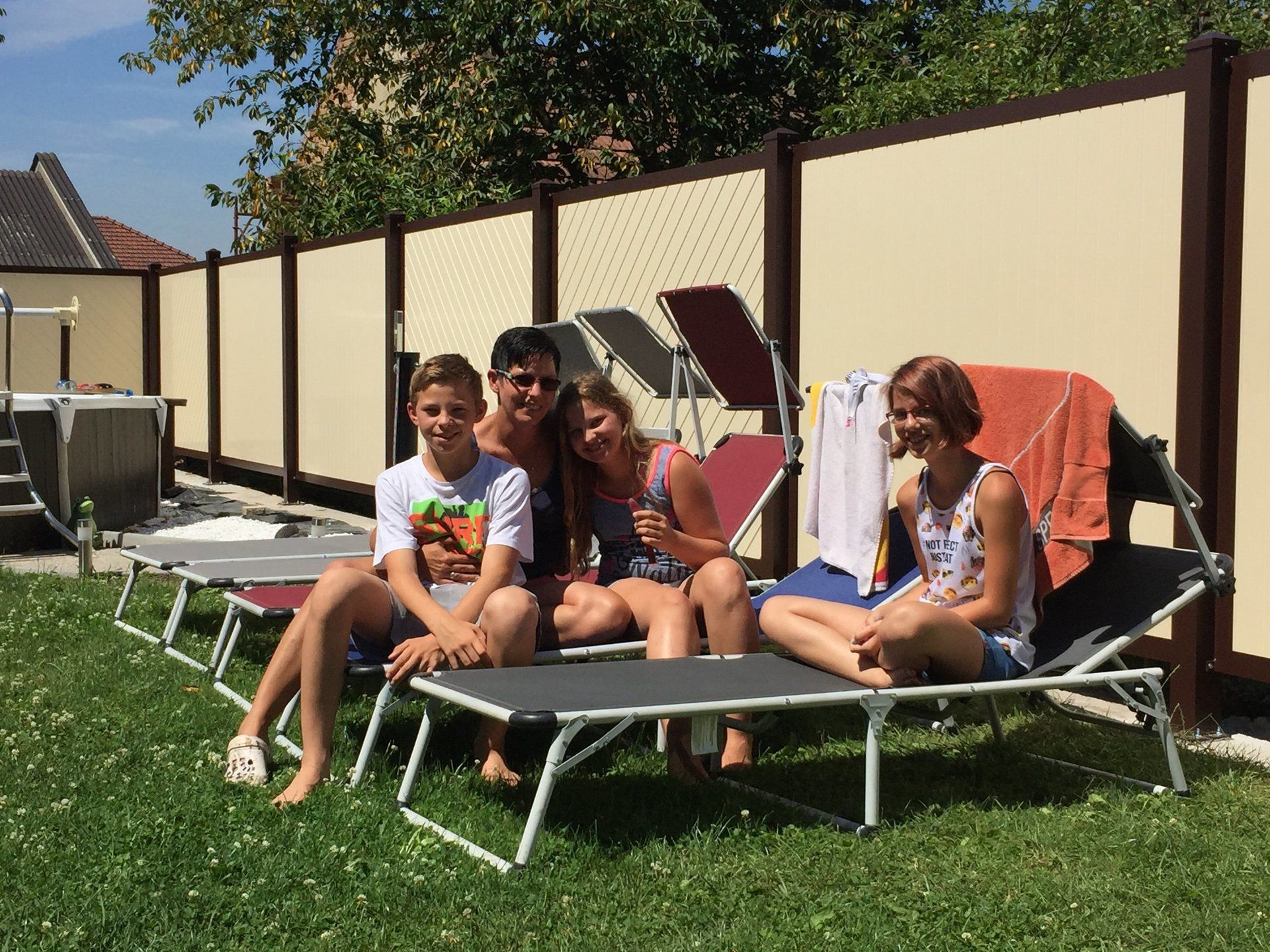 Eine Familie sitzt auf Liegestühlen in einem Hinterhof.