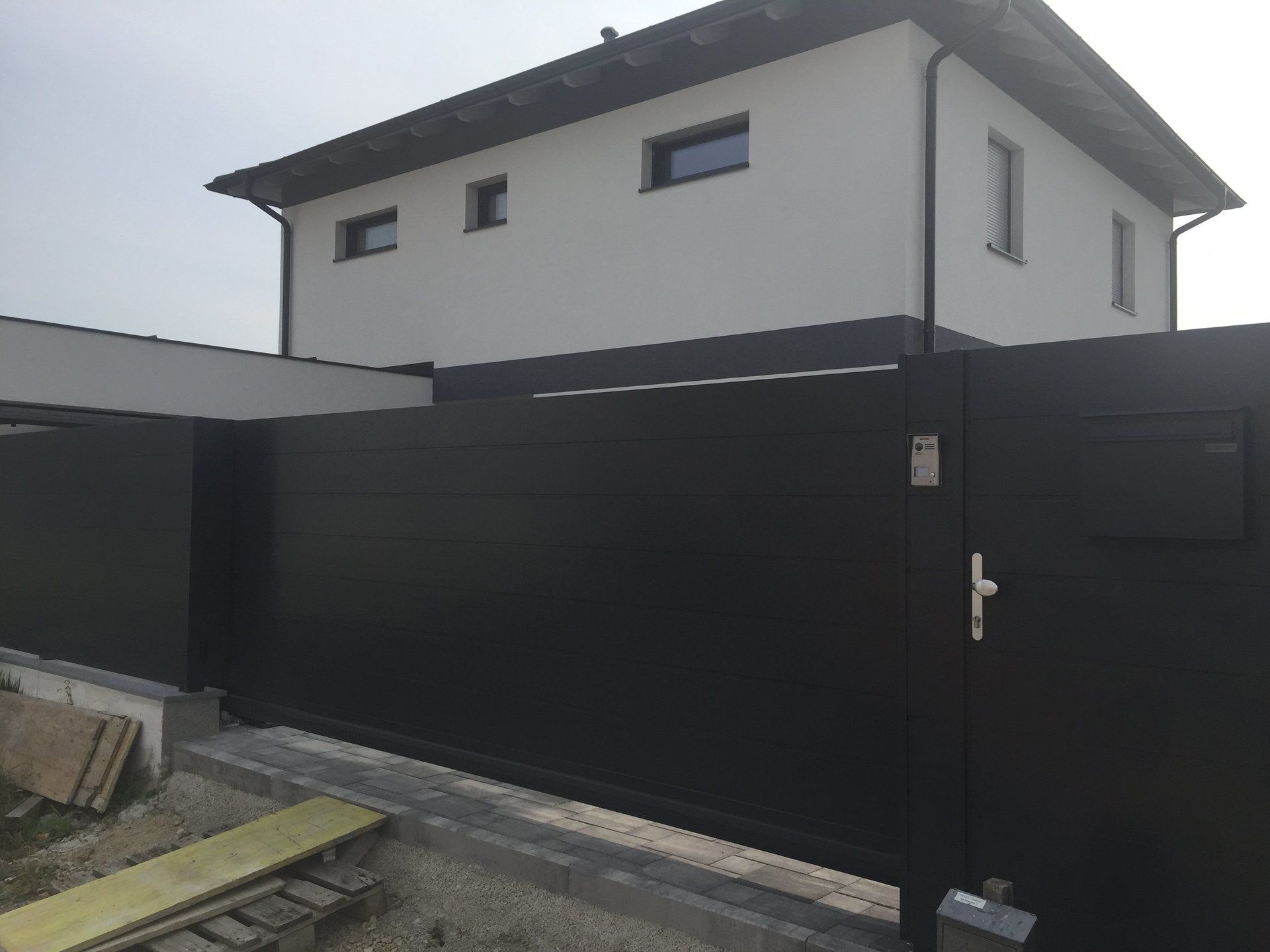 Ein weißes Haus mit einem schwarzen Tor davor