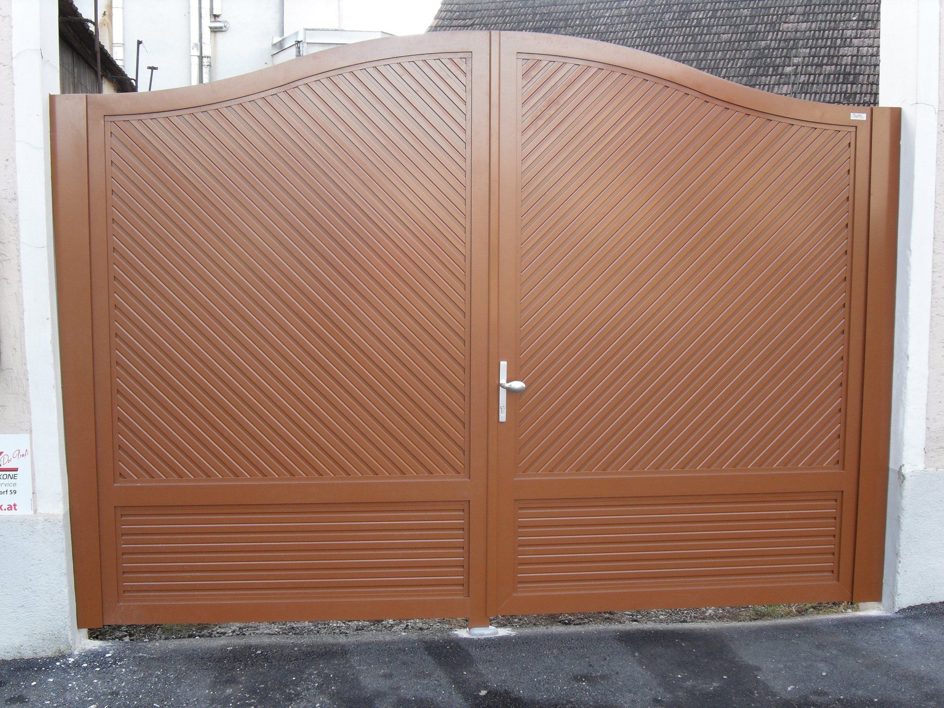 Ein braunes Holztor mit einem weißen Griff