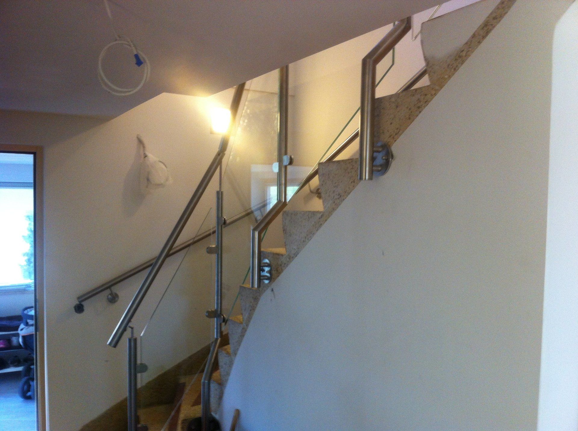 Eine Treppe mit Edelstahlgeländer und Glasgeländer