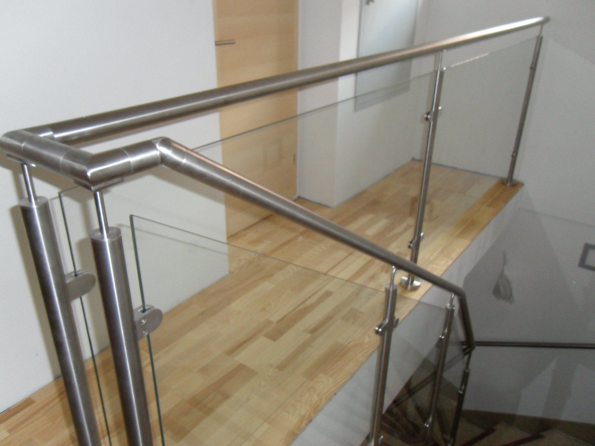 Eine Treppe mit Glasgeländer und Holzboden