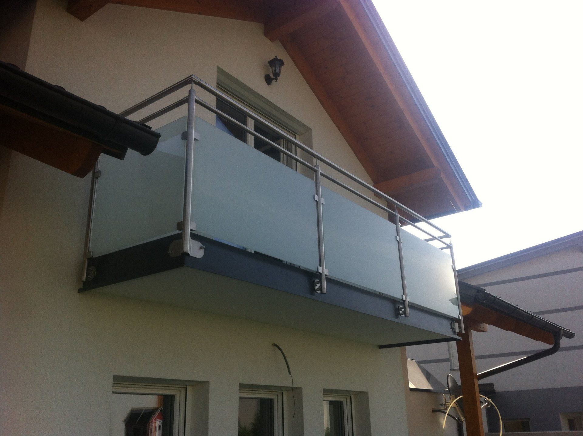 Ein Balkon an der Seite eines Hauses mit einem Edelstahlgeländer