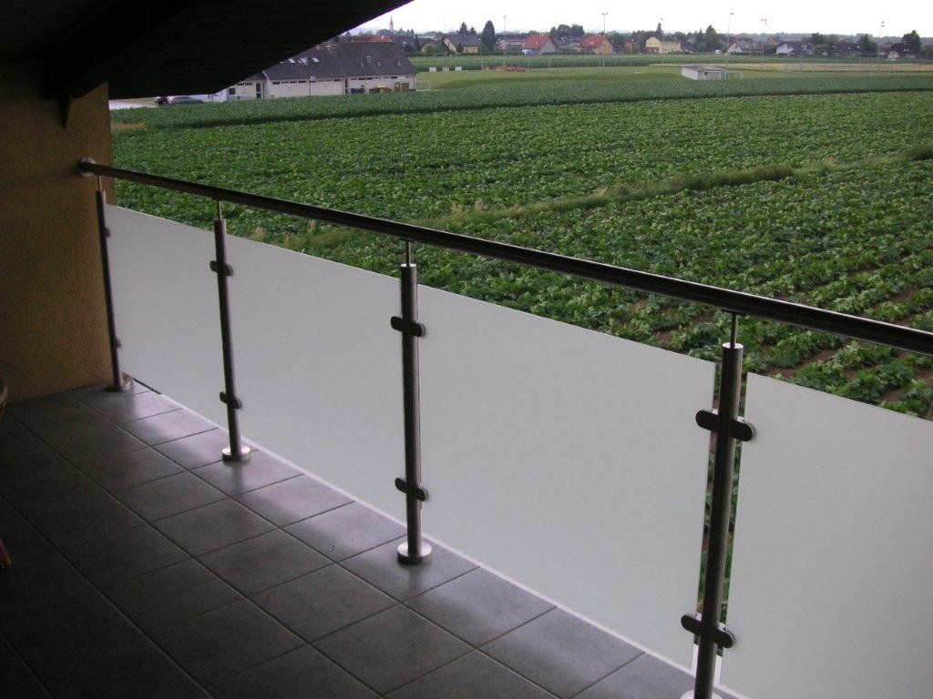 Ein Balkon mit Blick auf ein üppiges grünes Feld