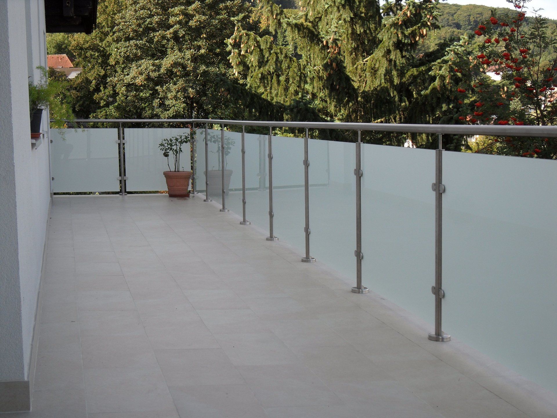 Ein Balkon mit Edelstahlgeländer und Milchglas