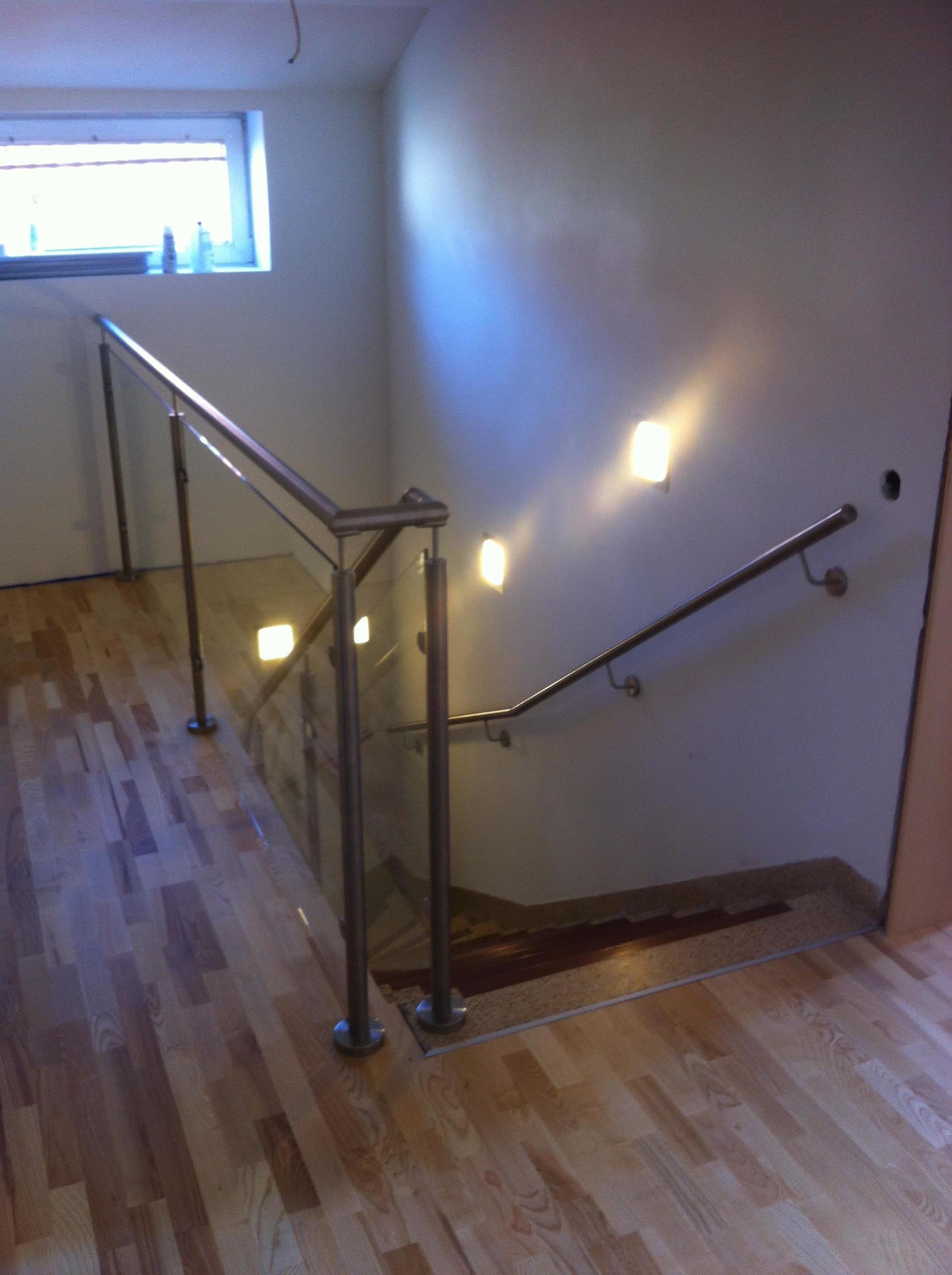 Eine Treppe mit Glasgeländer und Holzboden