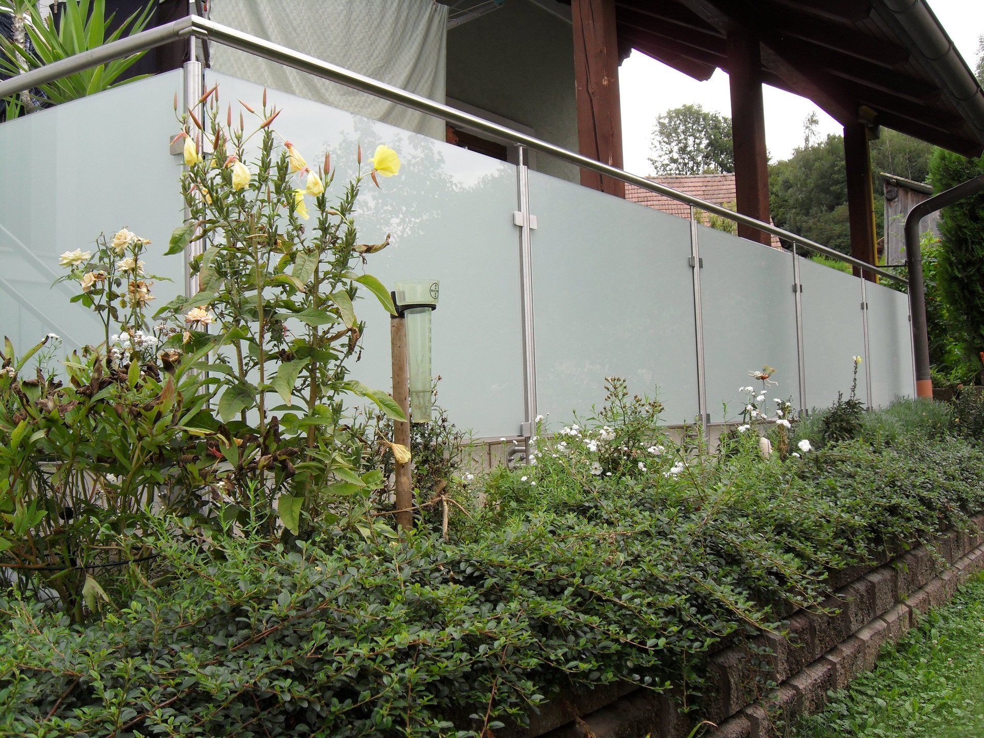 Ein Balkon mit Edelstahlgeländer und Milchglas