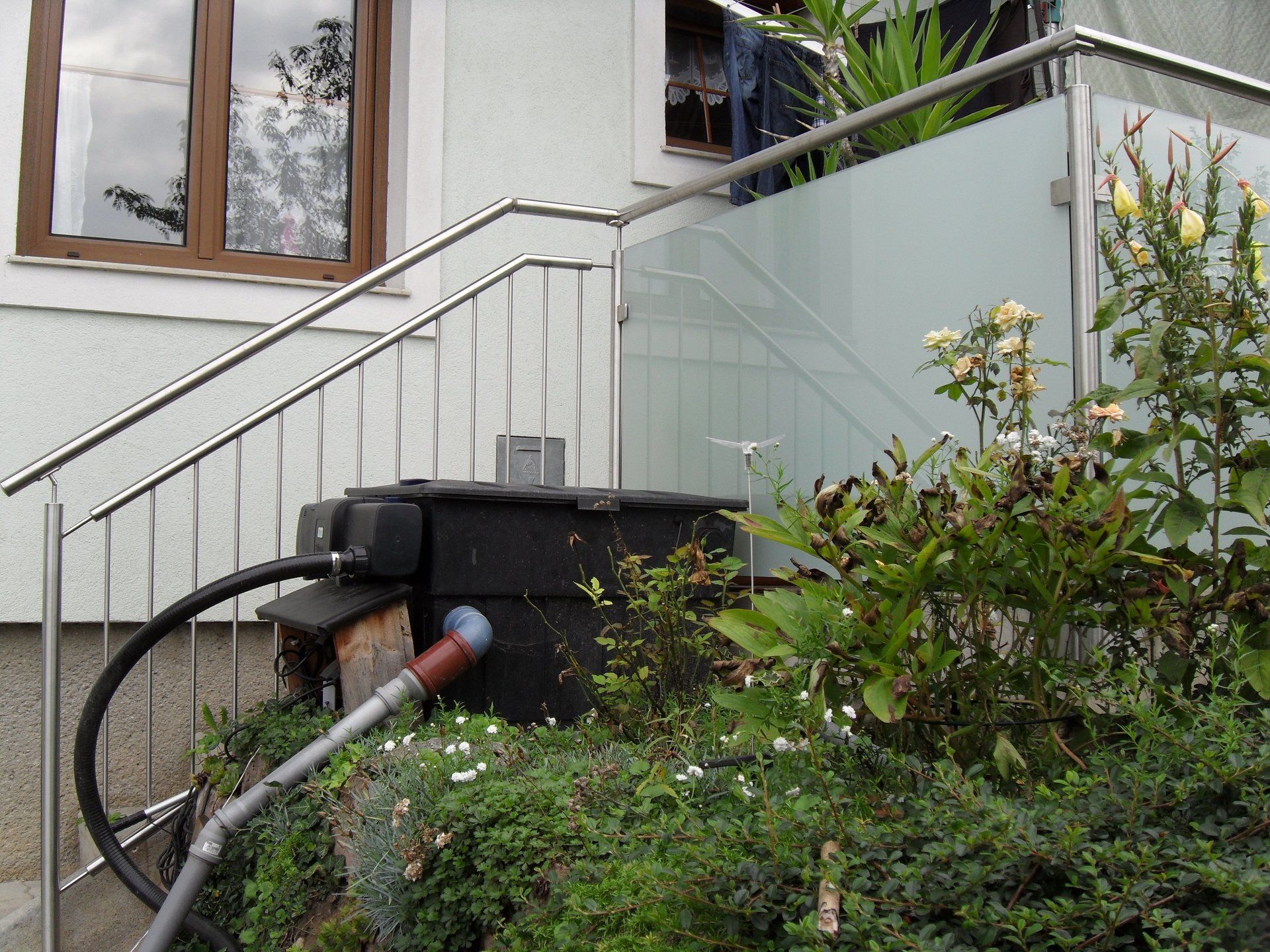 Ein Edelstahlgeländer mit daran befestigtem Schlauch