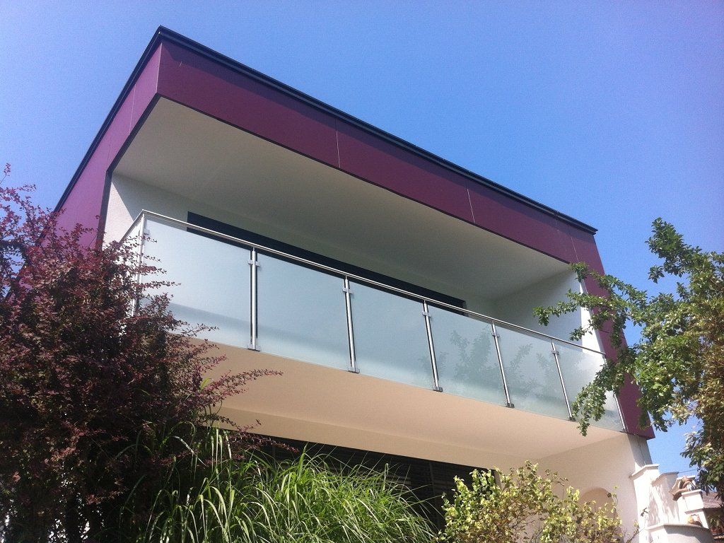 Ein Balkon mit Glasgeländer und violettem Dach