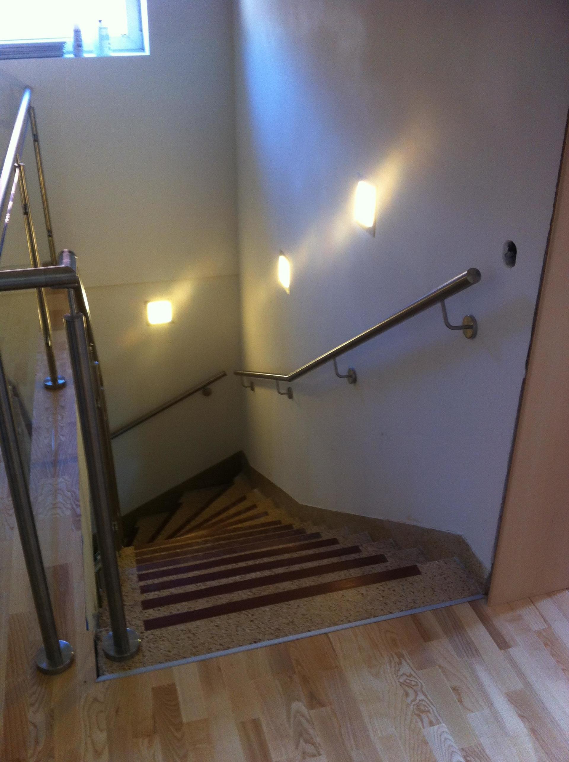 Eine Treppe mit Metallgeländer und Holzboden