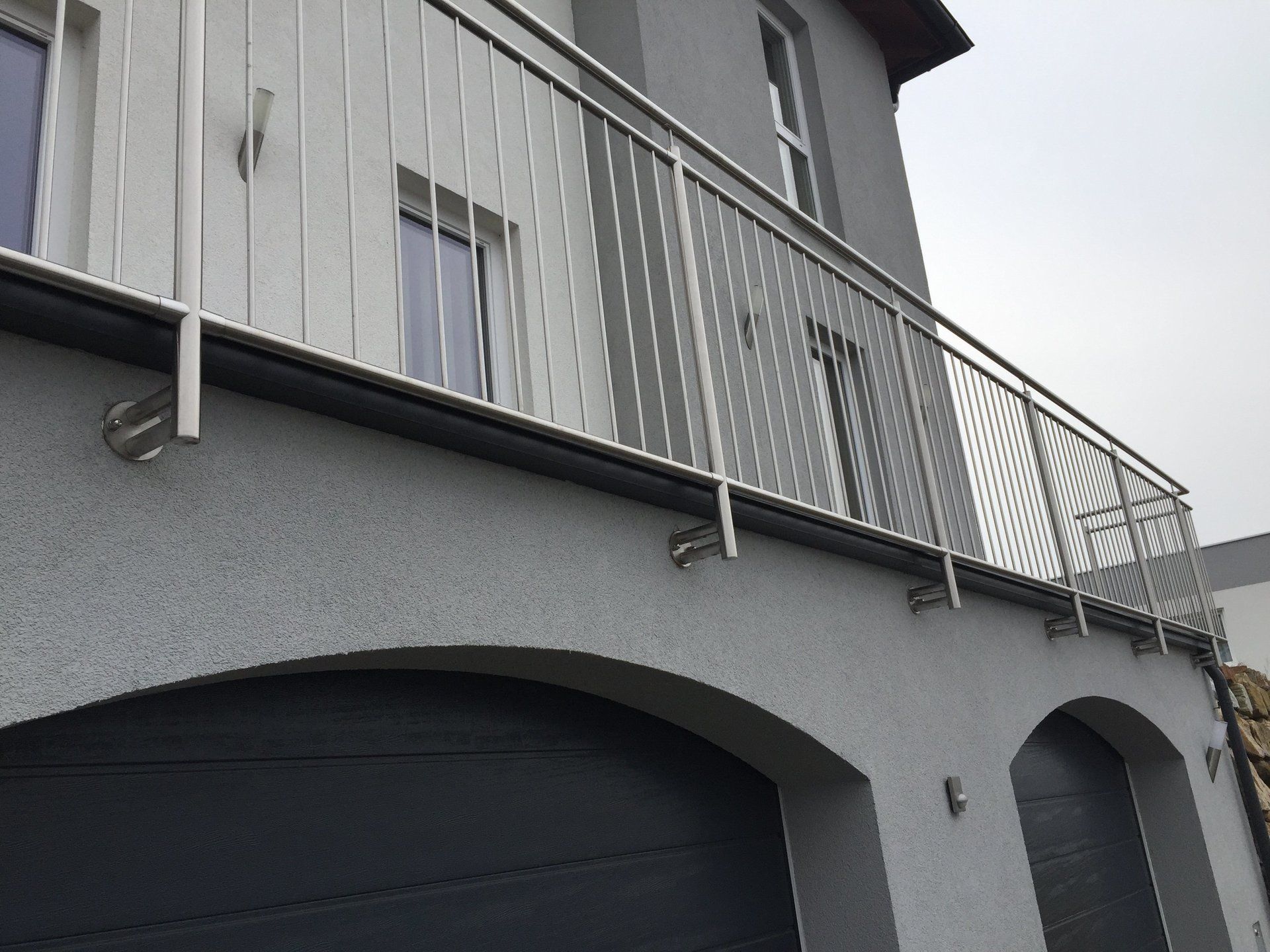 Ein Balkon mit einem Edelstahlgeländer an der Seite eines Gebäudes