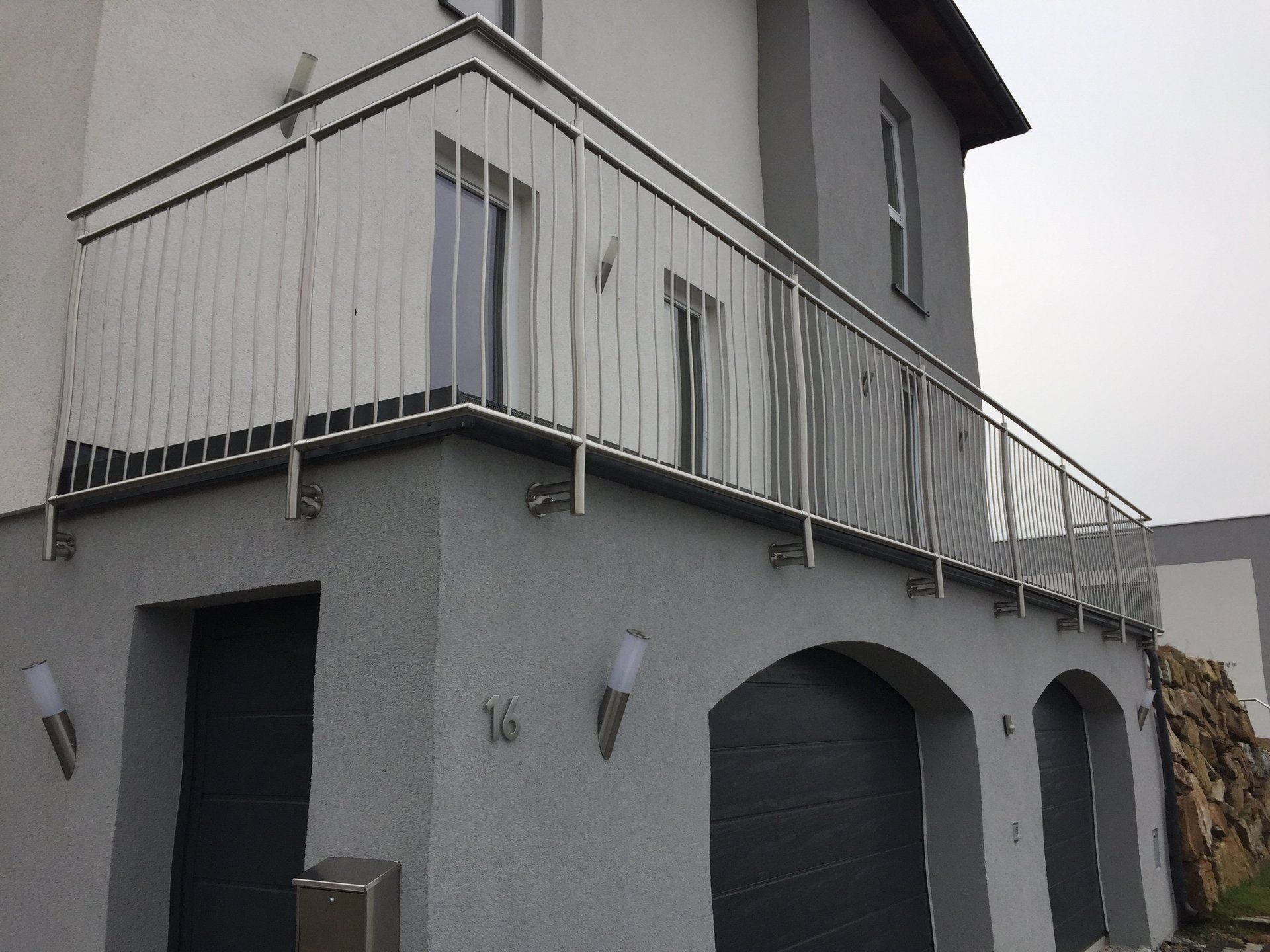 Ein Balkon an der Seite eines Gebäudes mit der Nummer 16 darauf