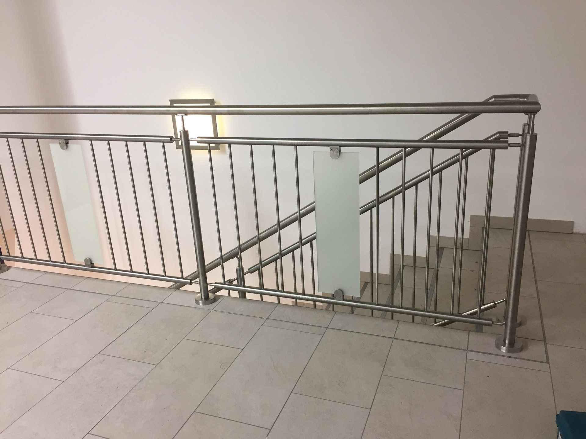 Eine Treppe mit Edelstahlgeländer und Glaspaneelen