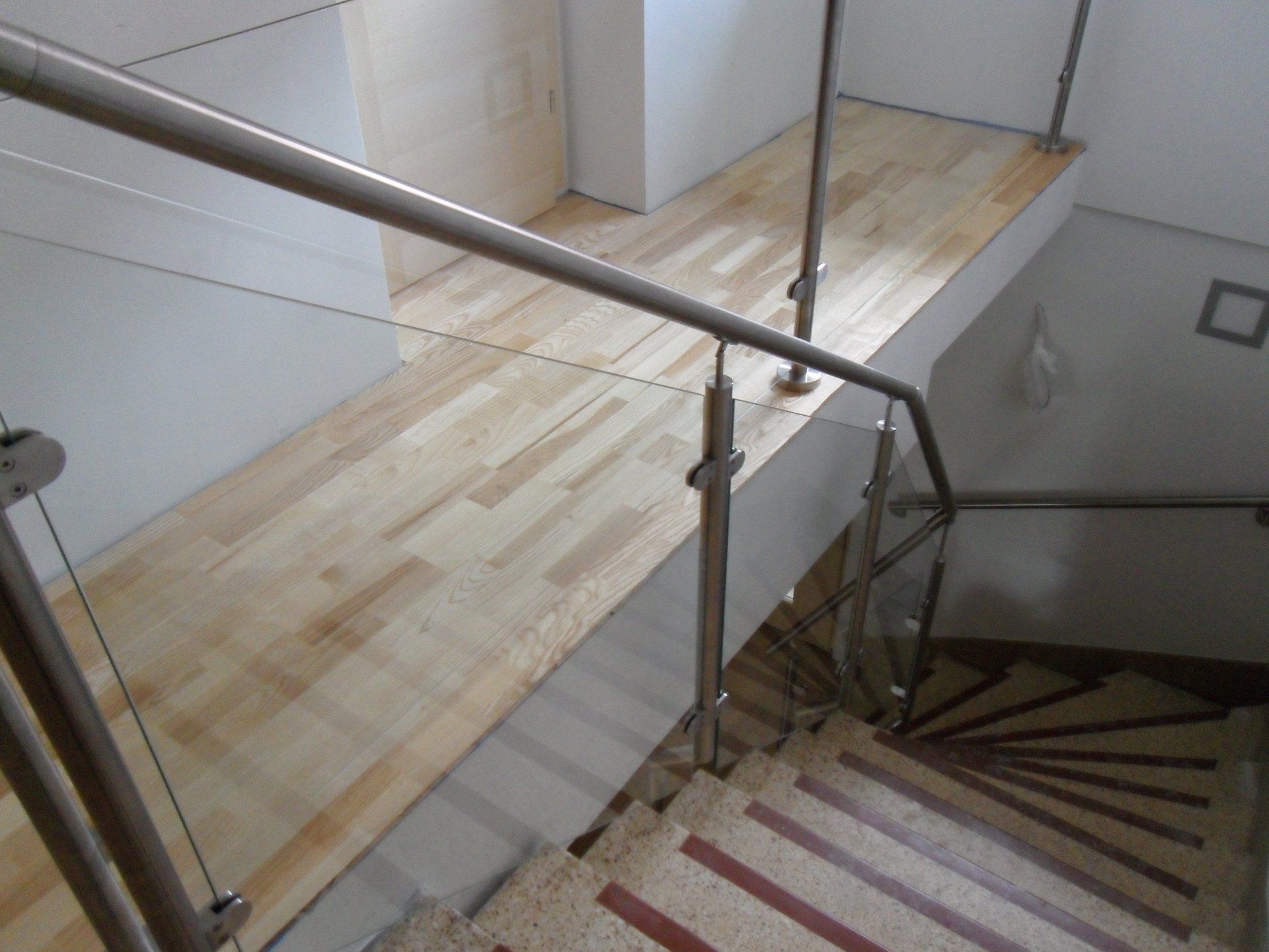 Eine Treppe mit Glasgeländer und Holzstufen