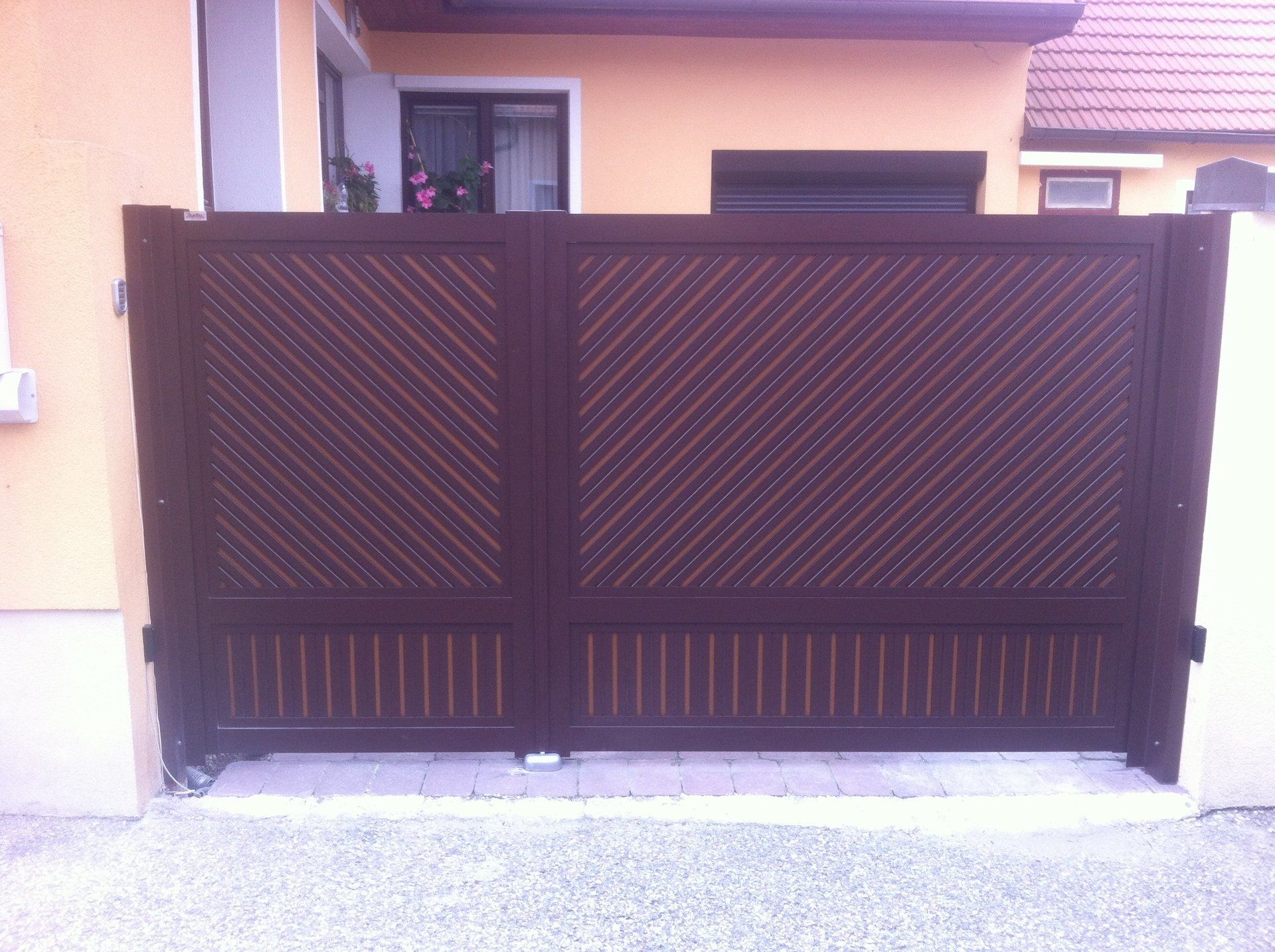 Vor einem Haus steht ein braunes Tor.