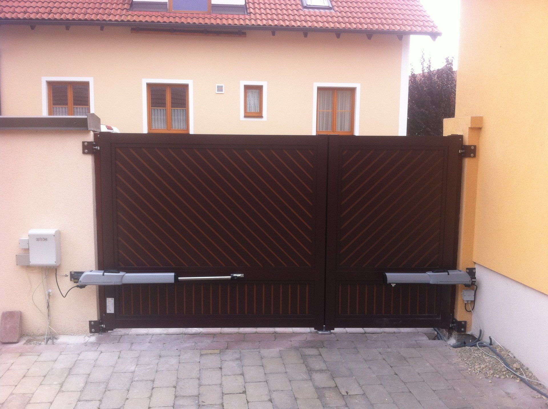 Vor einem Haus steht ein braunes Tor offen