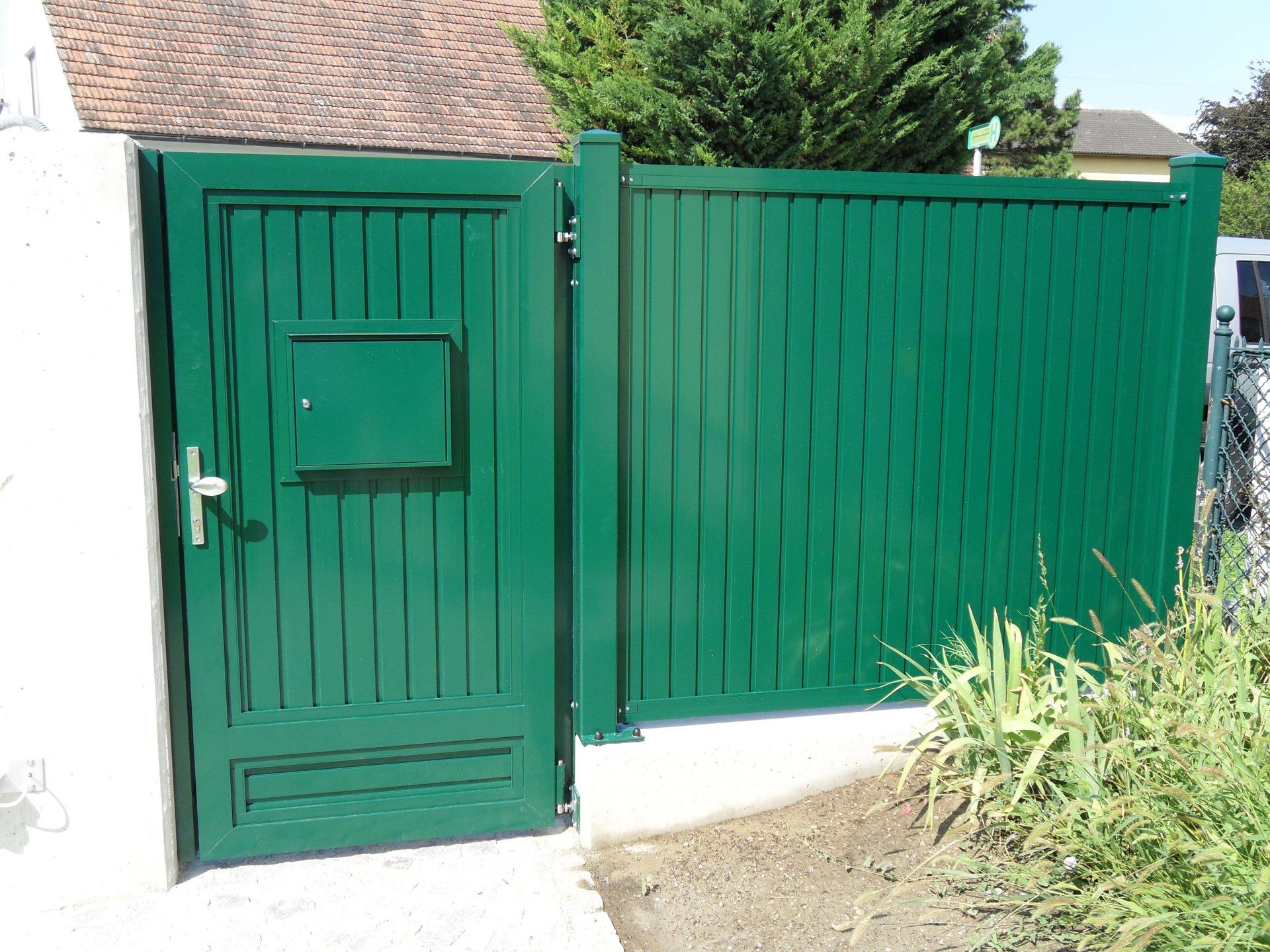 Ein grünes Tor mit einem Briefkasten darauf
