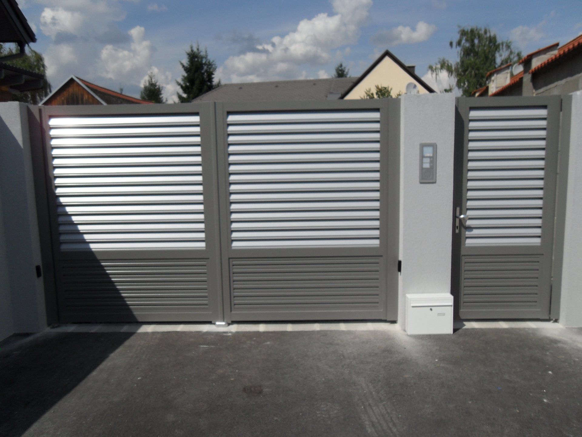 Ein Tor mit Fensterläden und einem Briefkasten davor