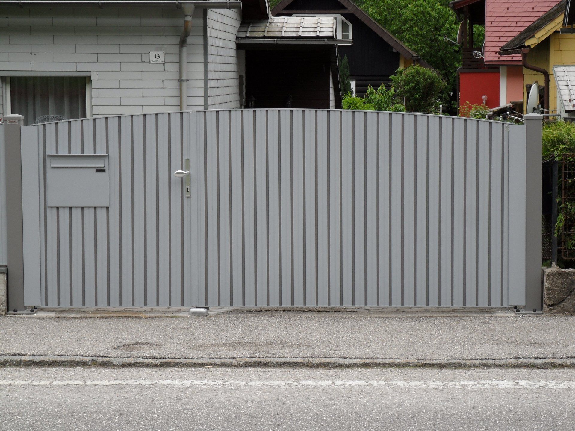 Ein graues Tor mit einem Briefkasten vor einem Haus
