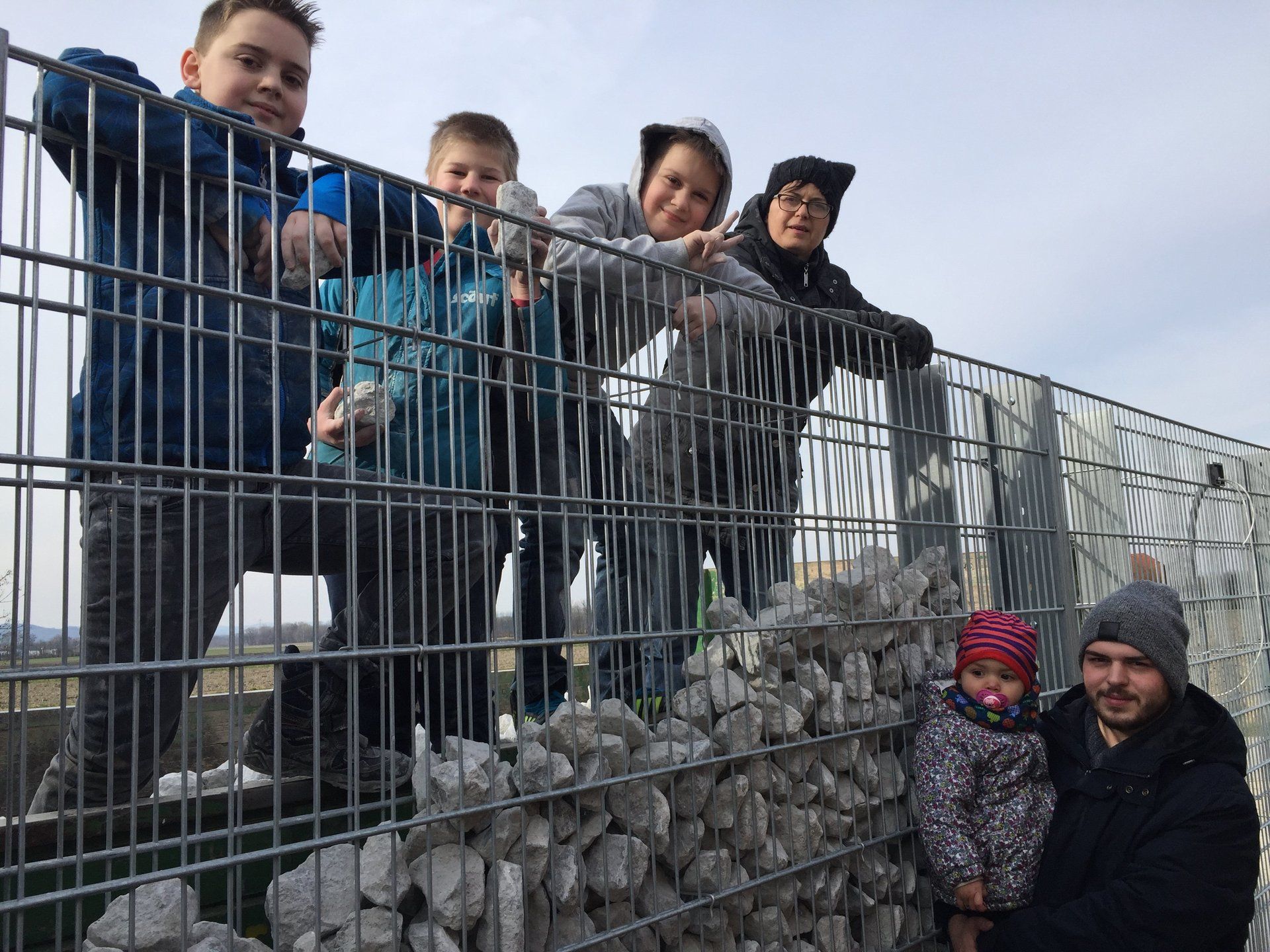 Eine Gruppe von Leuten steht auf einem Zaun.
