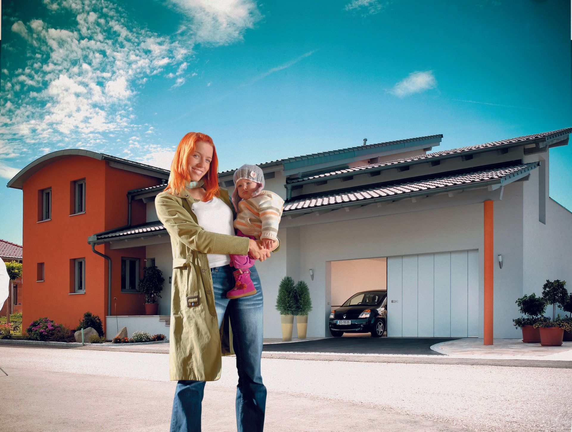 Eine Frau hält ein Baby vor einem Haus