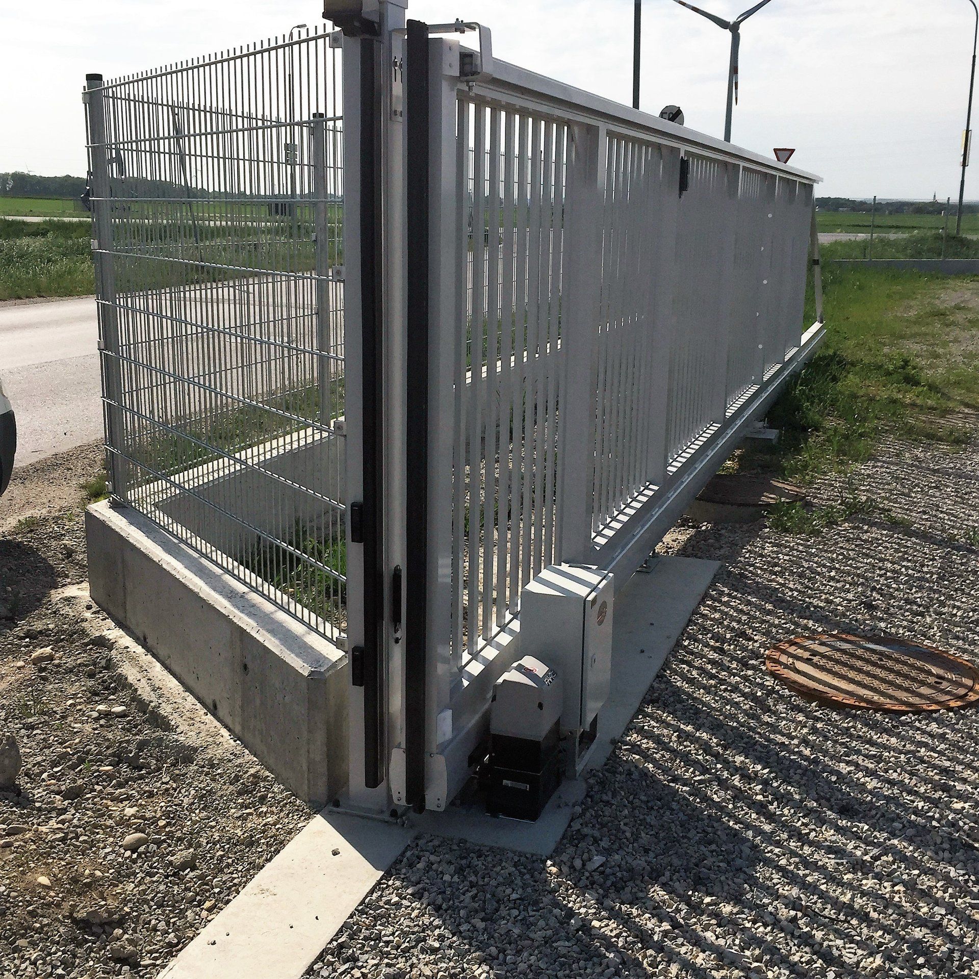 Ein Schiebetor mit ein paar Windmühlen im Hintergrund