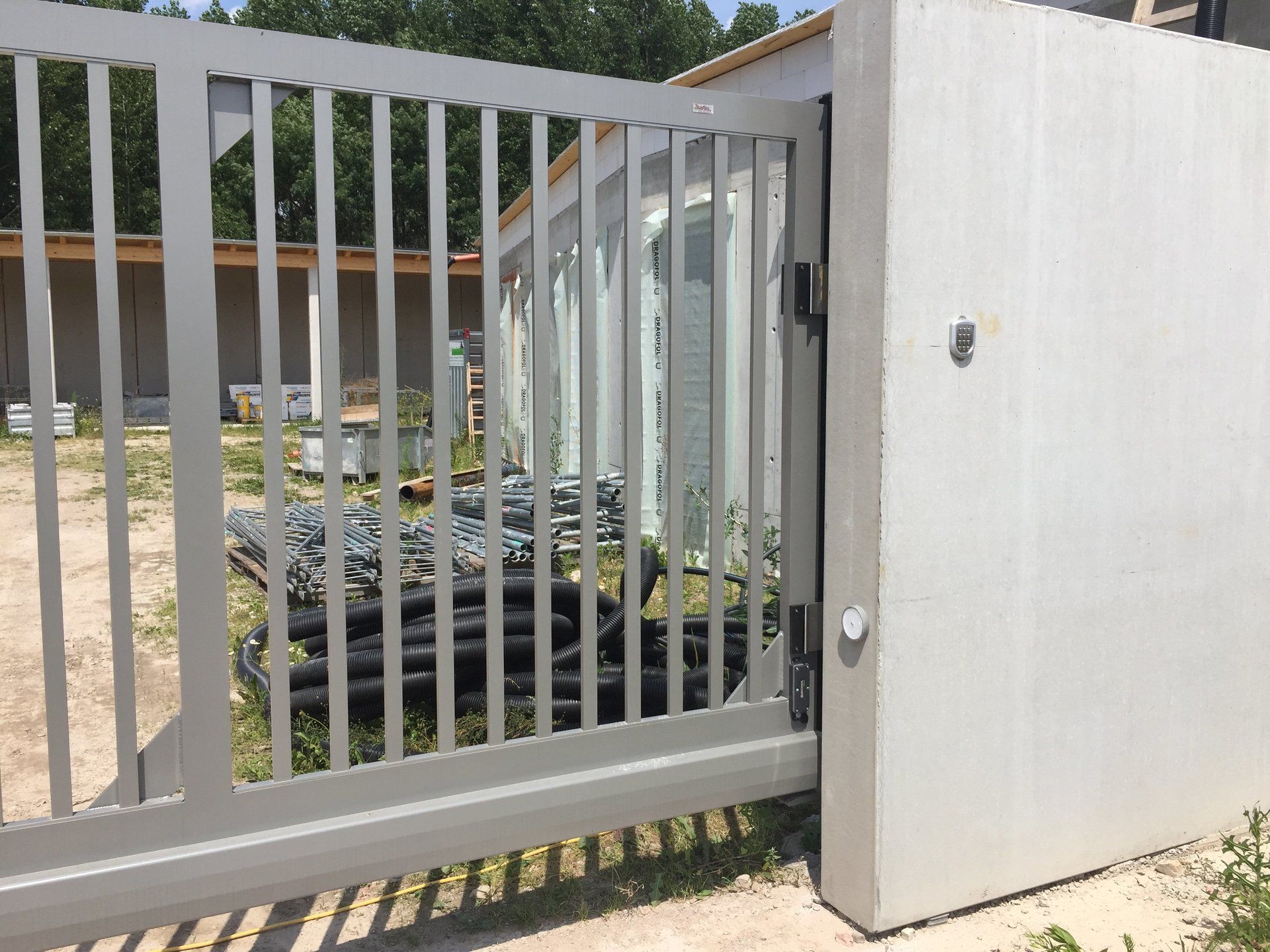 Ein Schiebetor mit einer Betonwand dahinter