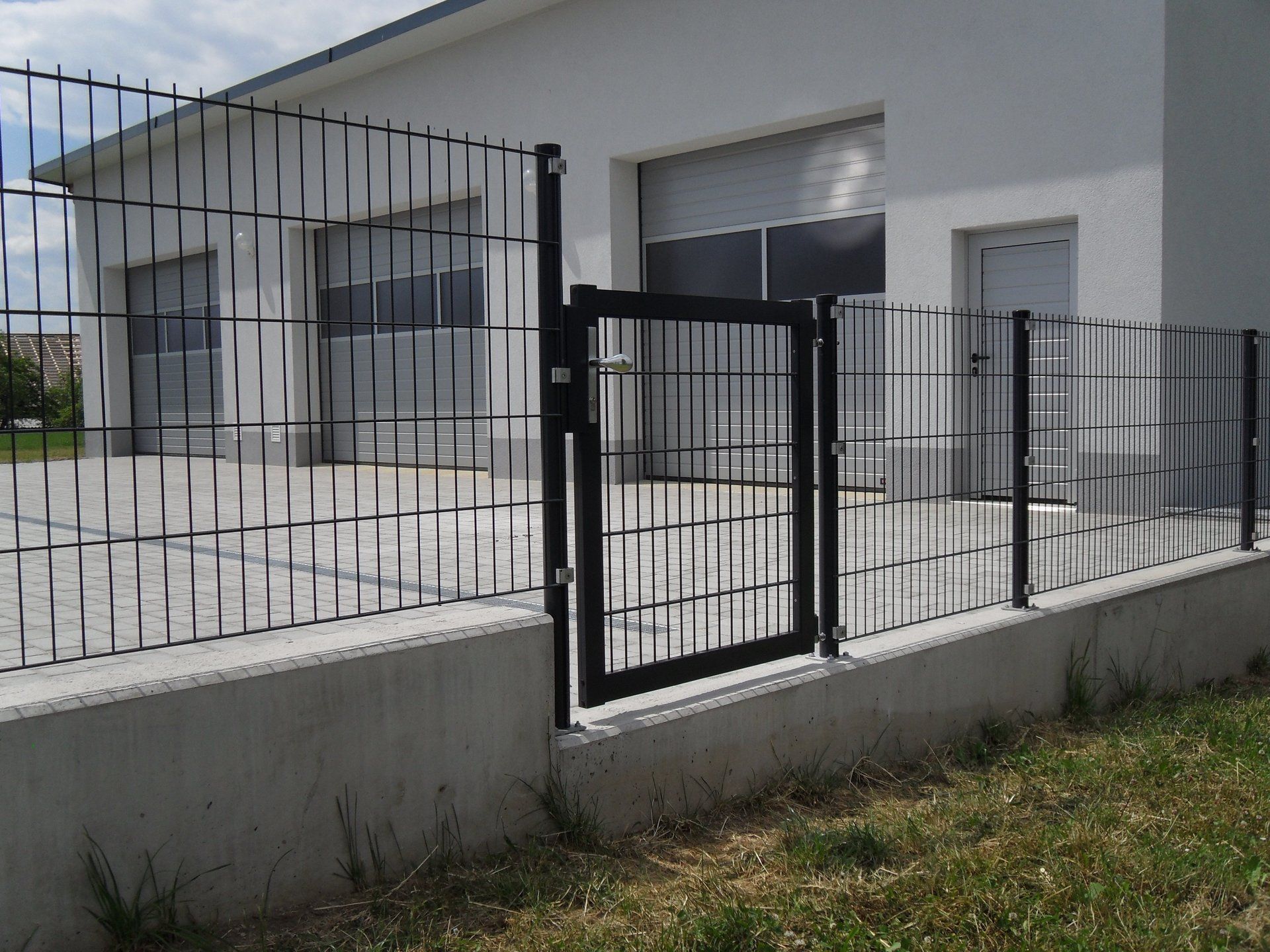 Ein Zaun mit einem Tor vor einem Gebäude
