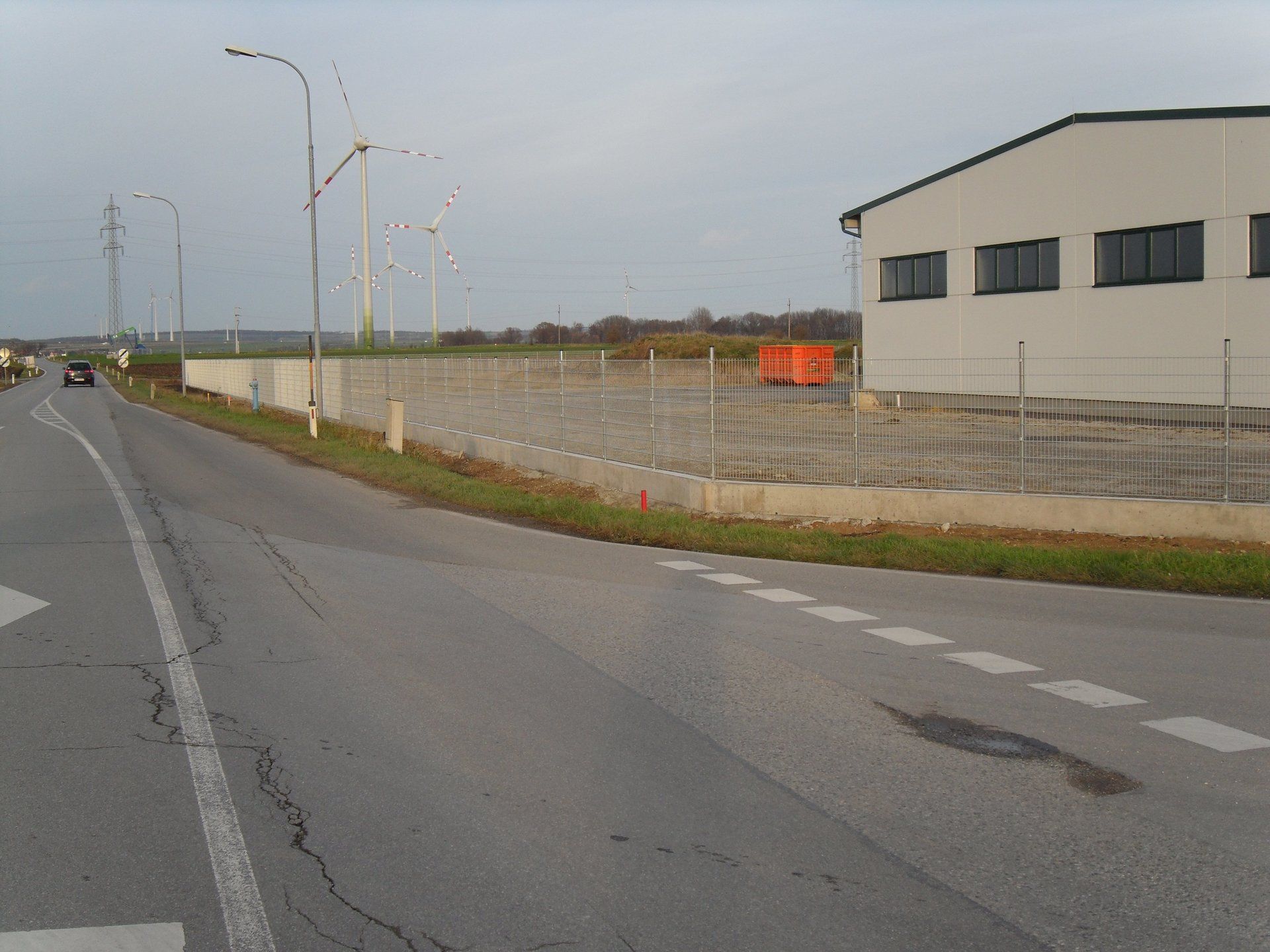 Ein Auto fährt eine Straße neben einem Gebäude entlang